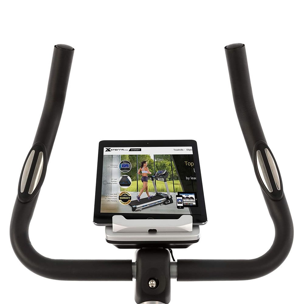 Heimtrainer mit Tablet-Halterung. Ein Tablet mit Trainings-App ist eingesetzt. Griffe und Display sind ebenfalls sichtbar.
