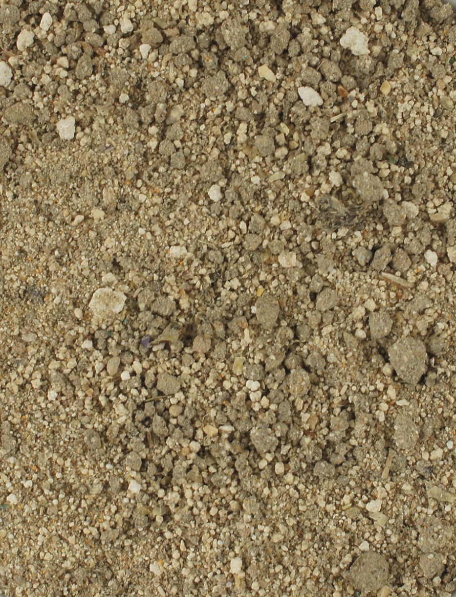 Nahaufnahme von losem, körnigem Material, hauptsächlich in Beige- und Brauntönen. Die Textur ist unregelmäßig und rau.