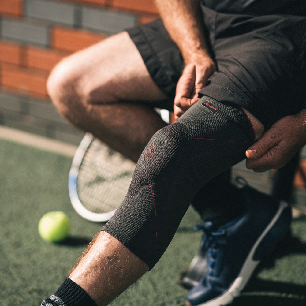 DONJOY GenuForce Kniebandage aus atmungsaktivem Material mit roter Naht und Pelotte.