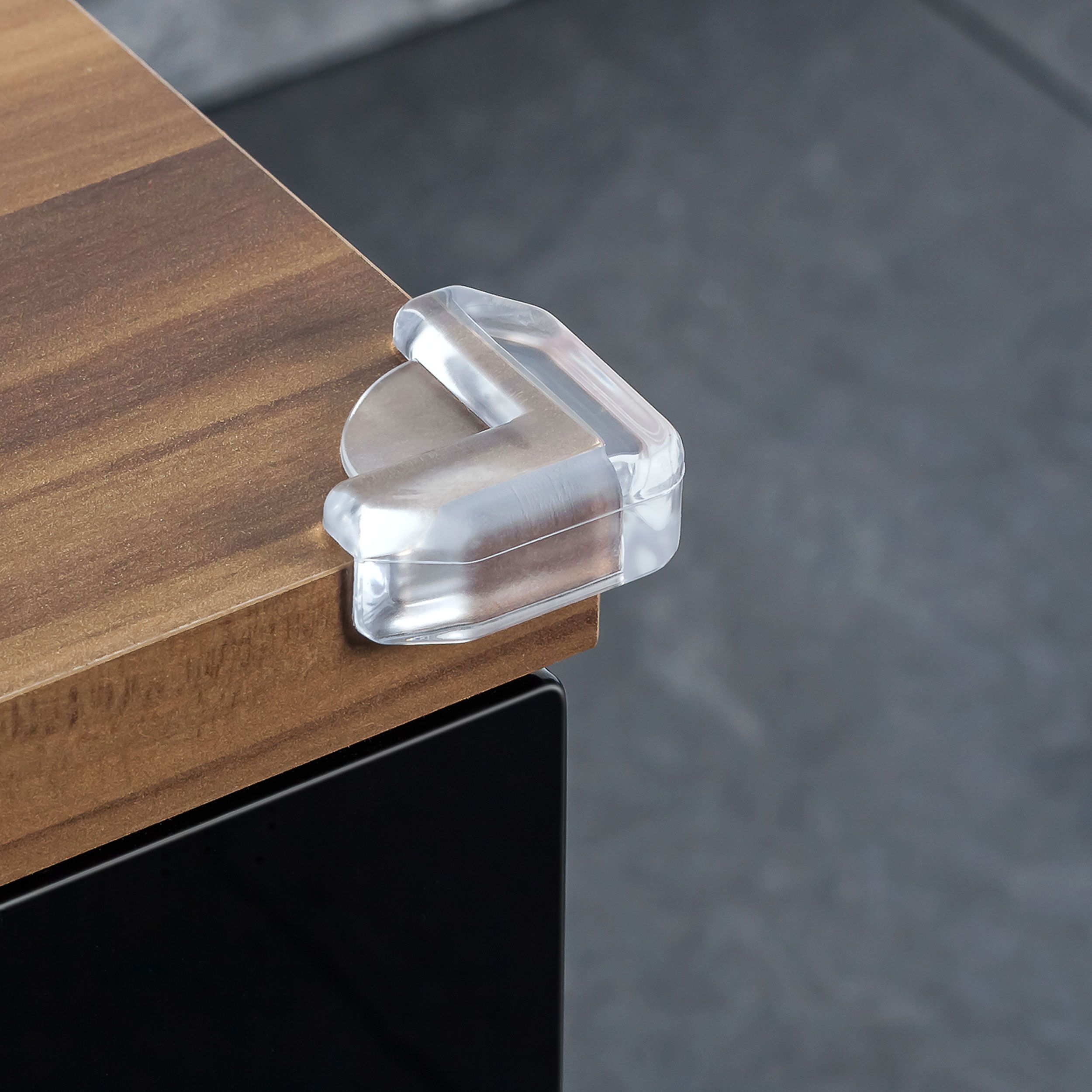 Transparenter Eckenschutz aus Kunststoff an einer Holzoberfläche.