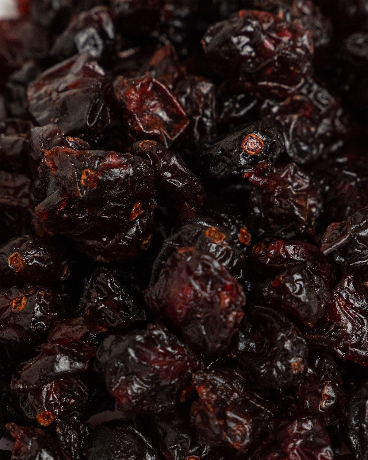 Nahaufnahme getrockneter Cranberries. Dunkelrote, runzelige Früchte. Detailaufnahme.
