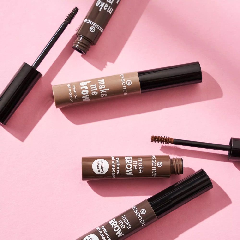 Mehrere Augenbrauengel-Mascara-Tuben und Bürsten. Braune Tuben mit schwarzem Deckel. Aufschrift: make me brow, eyebrow gel mascara, + filling fibers.