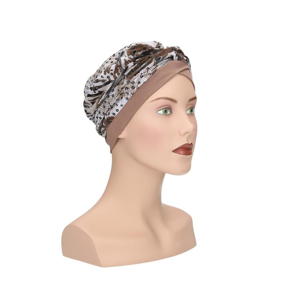 Turban Livia von Turbane, beige und gemustert. Auf einer Büste präsentiert. Dreiviertelansicht.