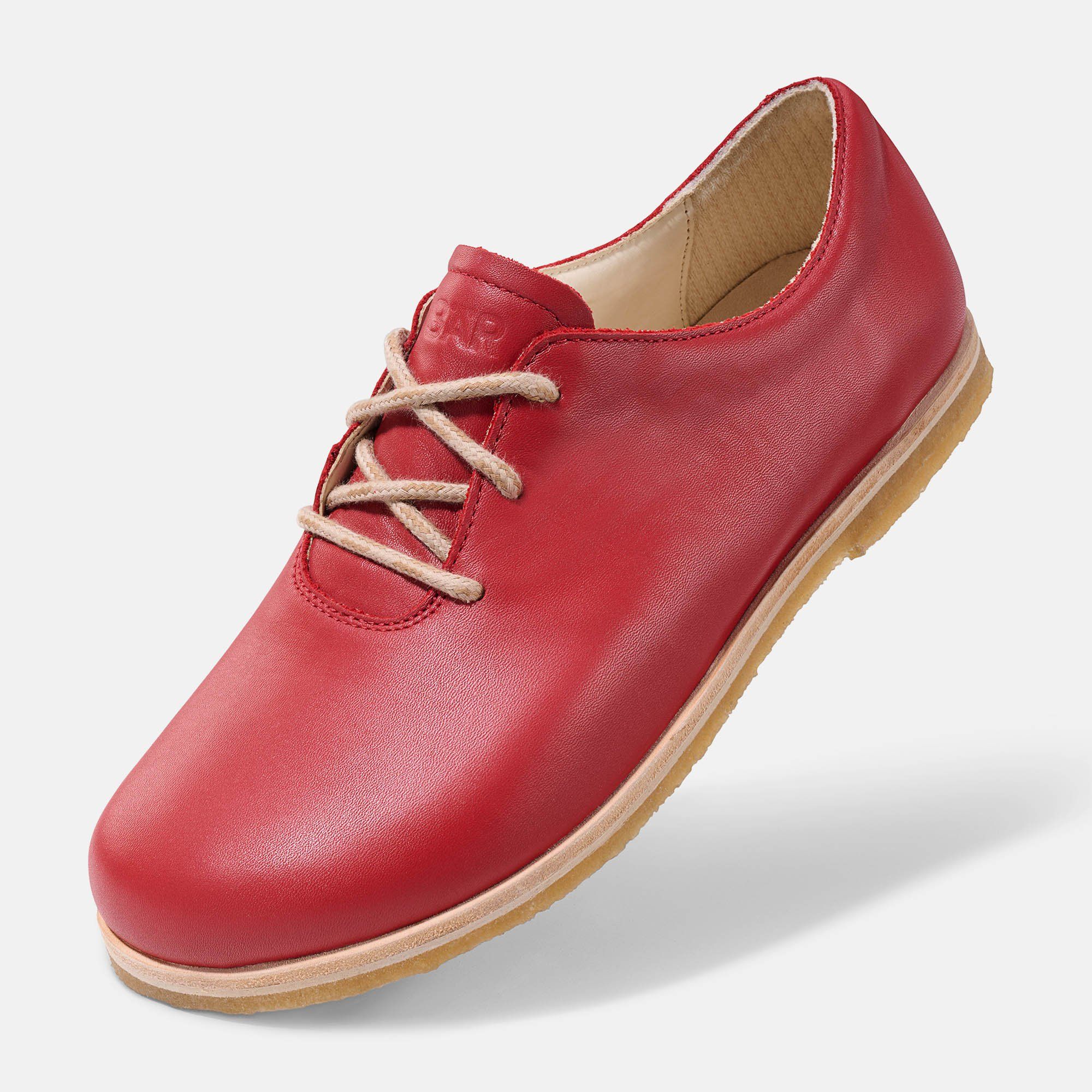 Roter Schnürschuh. Hellbraune Schnürsenkel. Helle Sohle. Ansicht von der Seite.