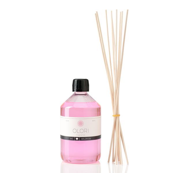 Eine Flasche mit rosa Flüssigkeit und schwarzem Deckel, daneben Holzstäbchen. Auf der Flasche steht OLORI Wildrose.
