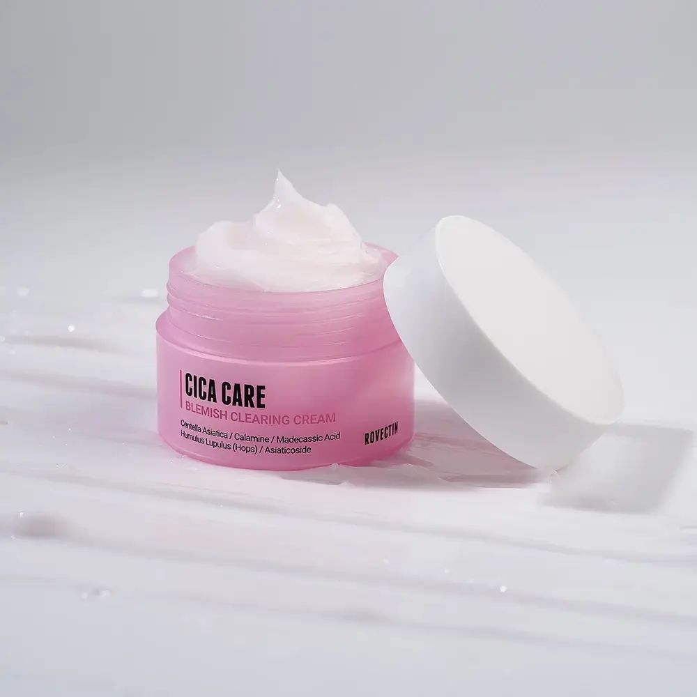 Geöffnete, rosa Creme-Dose mit weißem Deckel. Creme ist sichtbar. Aufschrift: Cica Care Blemish Clearing Cream. Marke: Rovectin.