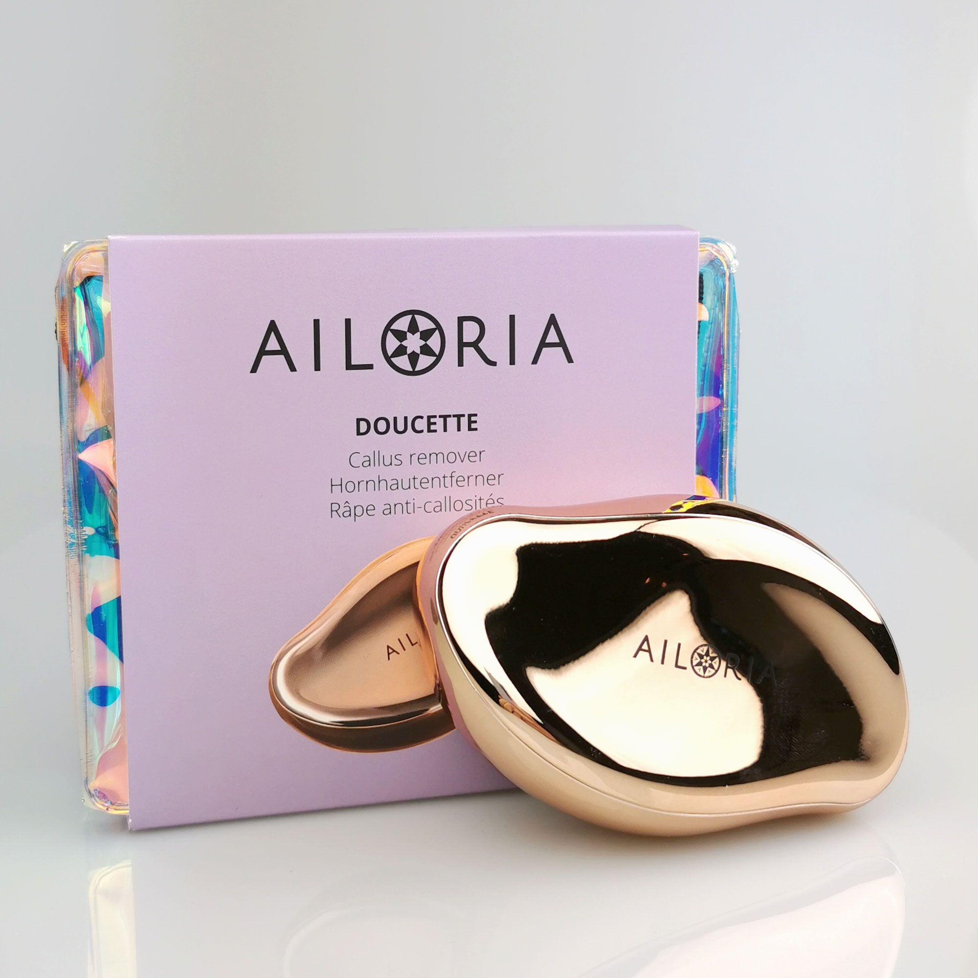 Produktverpackung und Hornhautentferner. AILORIA DOUCETTE. Verpackung mit Produktnamen.