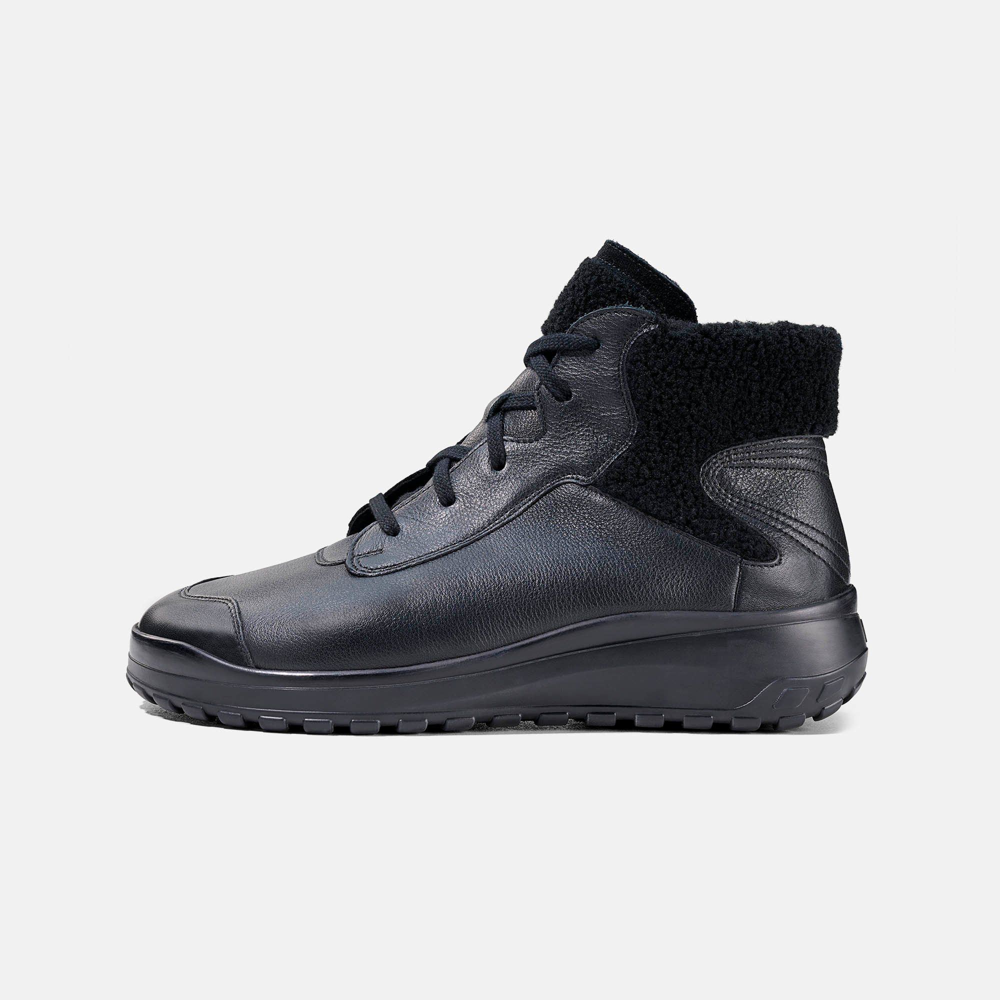 Schwarze Damen-Stiefelette aus Leder, Seitenansicht mit Lammfellkragen.