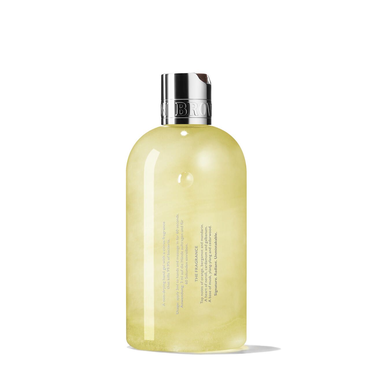 Rückansicht der Handdesinfektionsmittelflasche. Aufschrift: Molton Brown. Text über den Duft. Gelbe Flüssigkeit in einer Flasche mit silbernem Deckel.