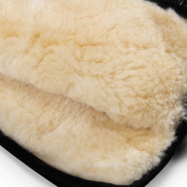 Nahaufnahme des Innenfutters eines Handwärmers. Cremefarbenes Lammfell mit schwarzem Rand.