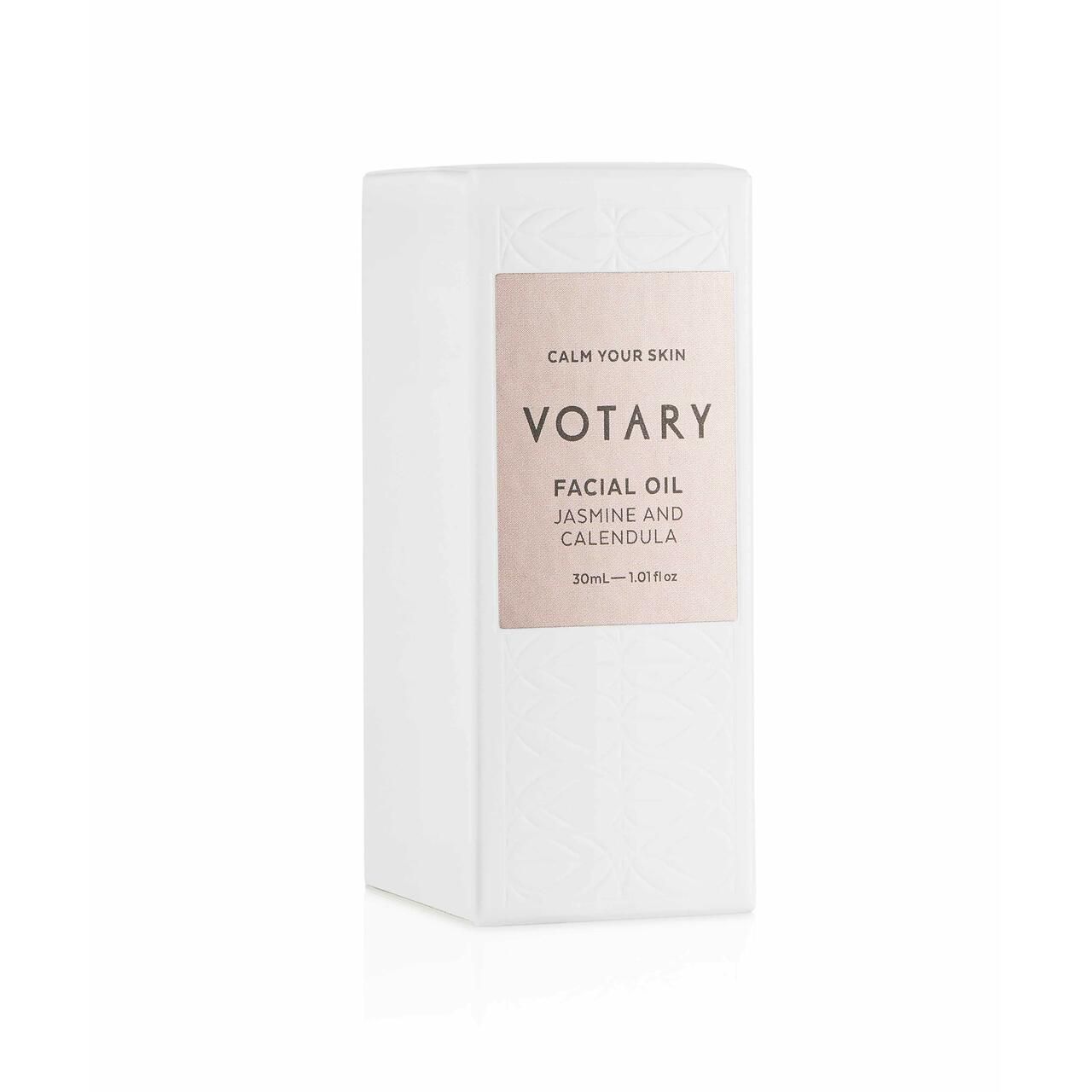 Weiße, sechseckige Verpackung. Etikett mit Text: Votary Facial Oil Jasmine & Calendula. 30ml.