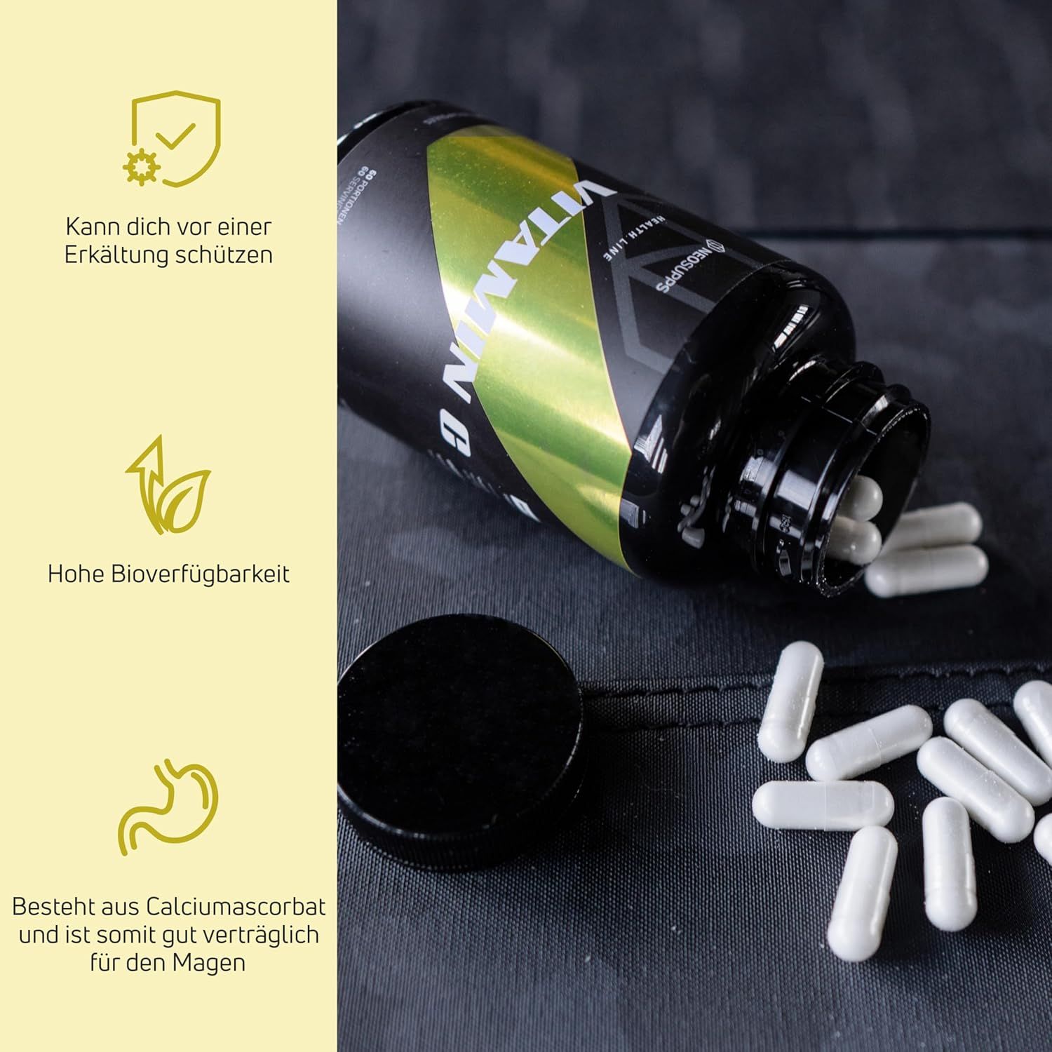 Schwarze Flasche mit weißen Kapseln daneben. Offener Deckel. Aufschrift Vitamin C. Einige Kapseln liegen verstreut.