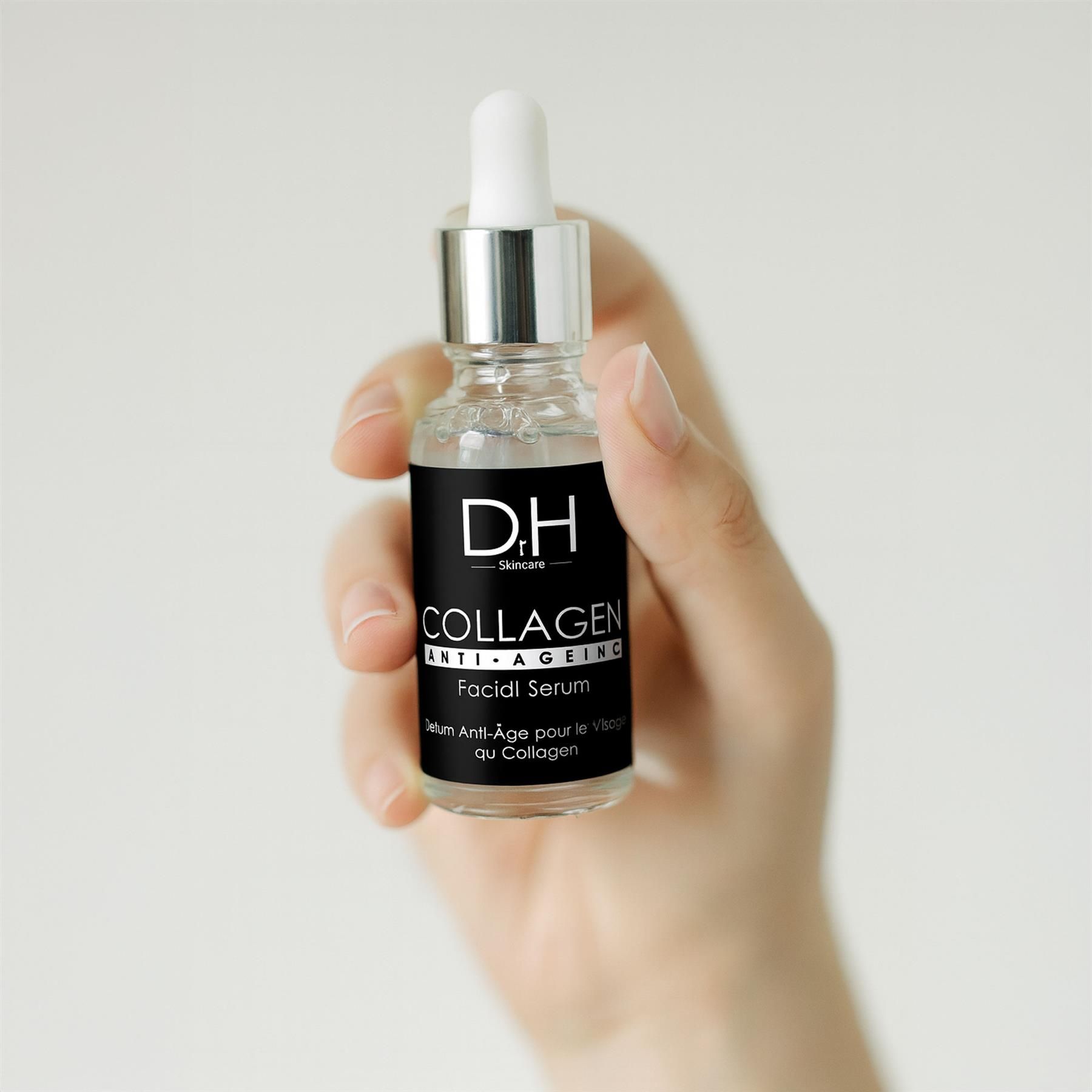 Hand hält Dr H Skincare Kollagen Anti-Aging Gesichtsserum in Glasflasche mit Pipette.