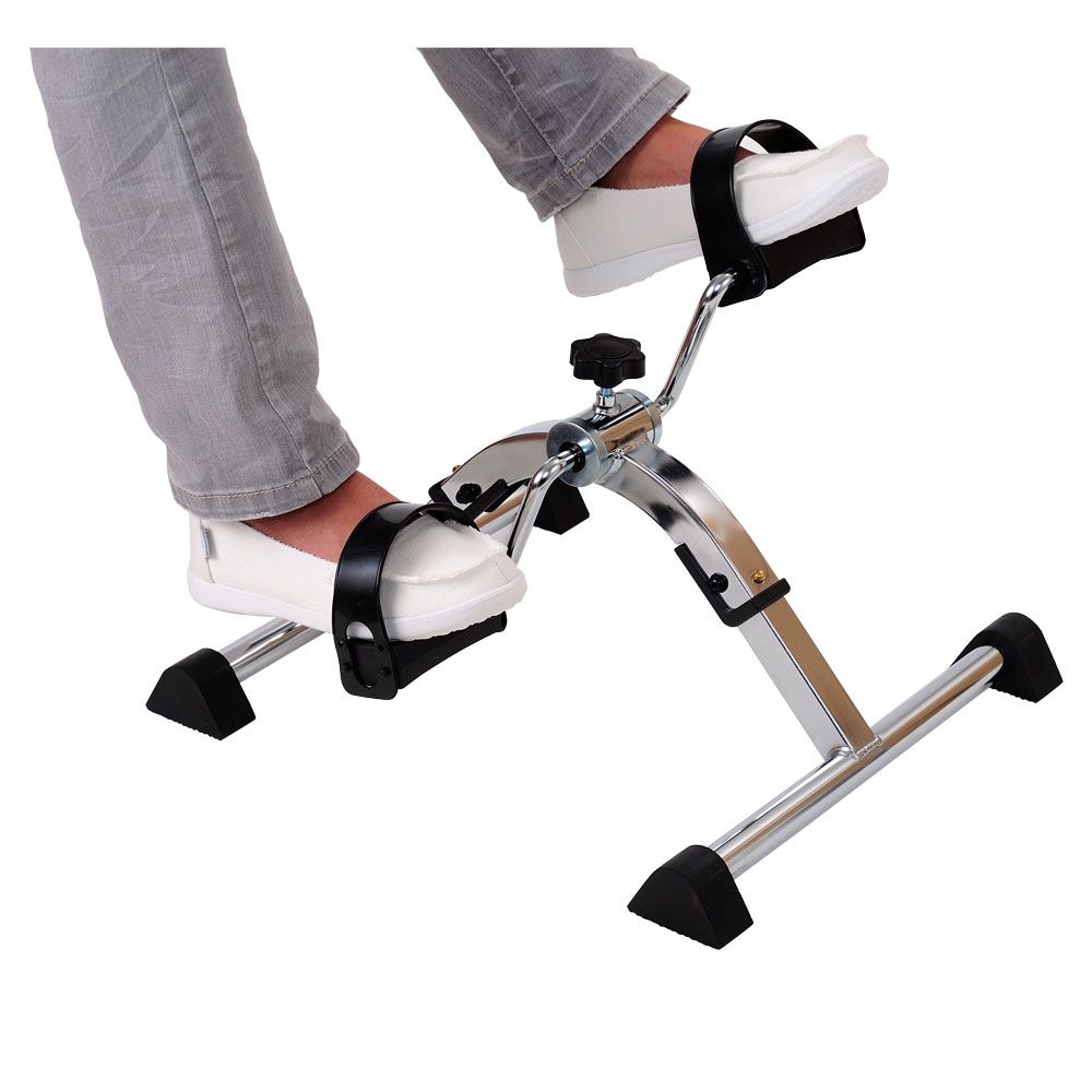 Person benutzt Pedaltrainer mit Füßen auf Pedalen. Metallrahmen, schwarze Pedale und Fußstützen. Einstellbarer Widerstand.