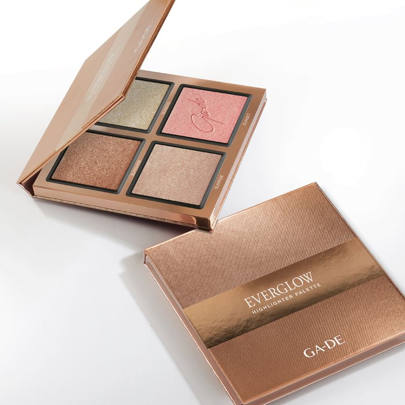 Ga-De Everglow Highlighter Palette. Geöffnete und geschlossene goldfarbene Paletten. Vier Highlighter-Farben sichtbar. Markenname auf der Verpackung.