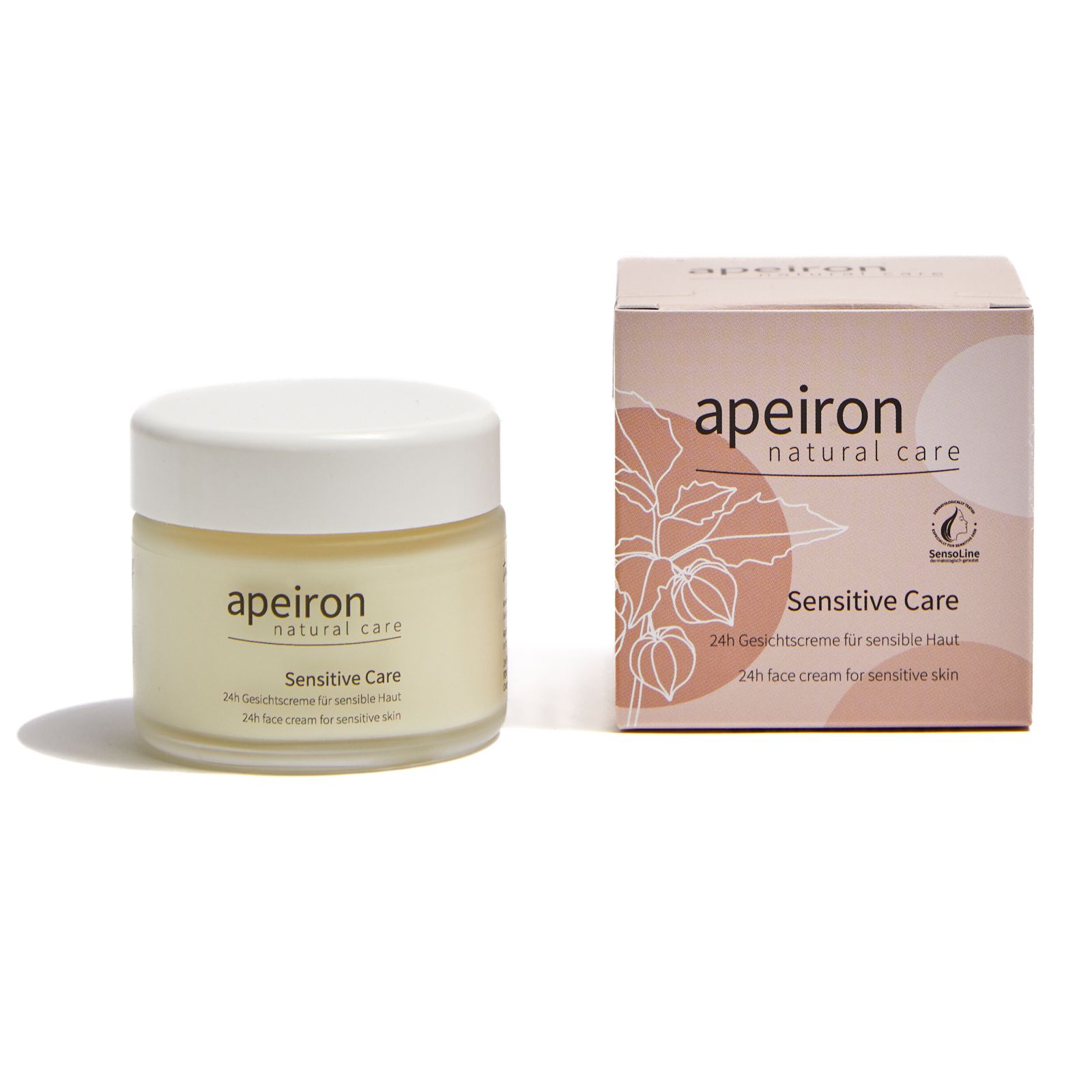 Creme-Glas und Karton. Aufschrift: Apeiron, Sensitive Care, 24h Gesichtscreme für sensible Haut. Karton mit Illustration.
