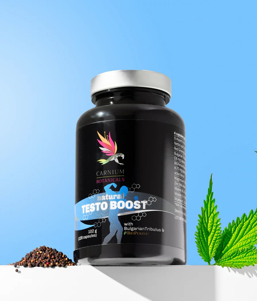Schwarze Kapsel-Flasche mit silbernem Deckel, neben Kräutern und Samen. Etikett zeigt "Natural Testo Boost".