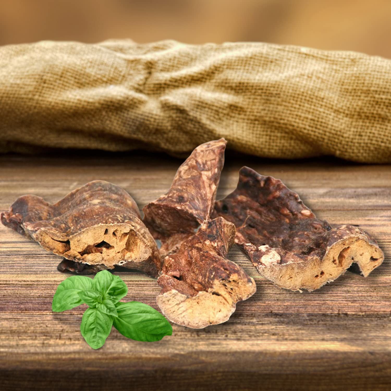 Getrocknete Rinderlunge, 4 Stücke, auf Holz. Basilikumblätter.
