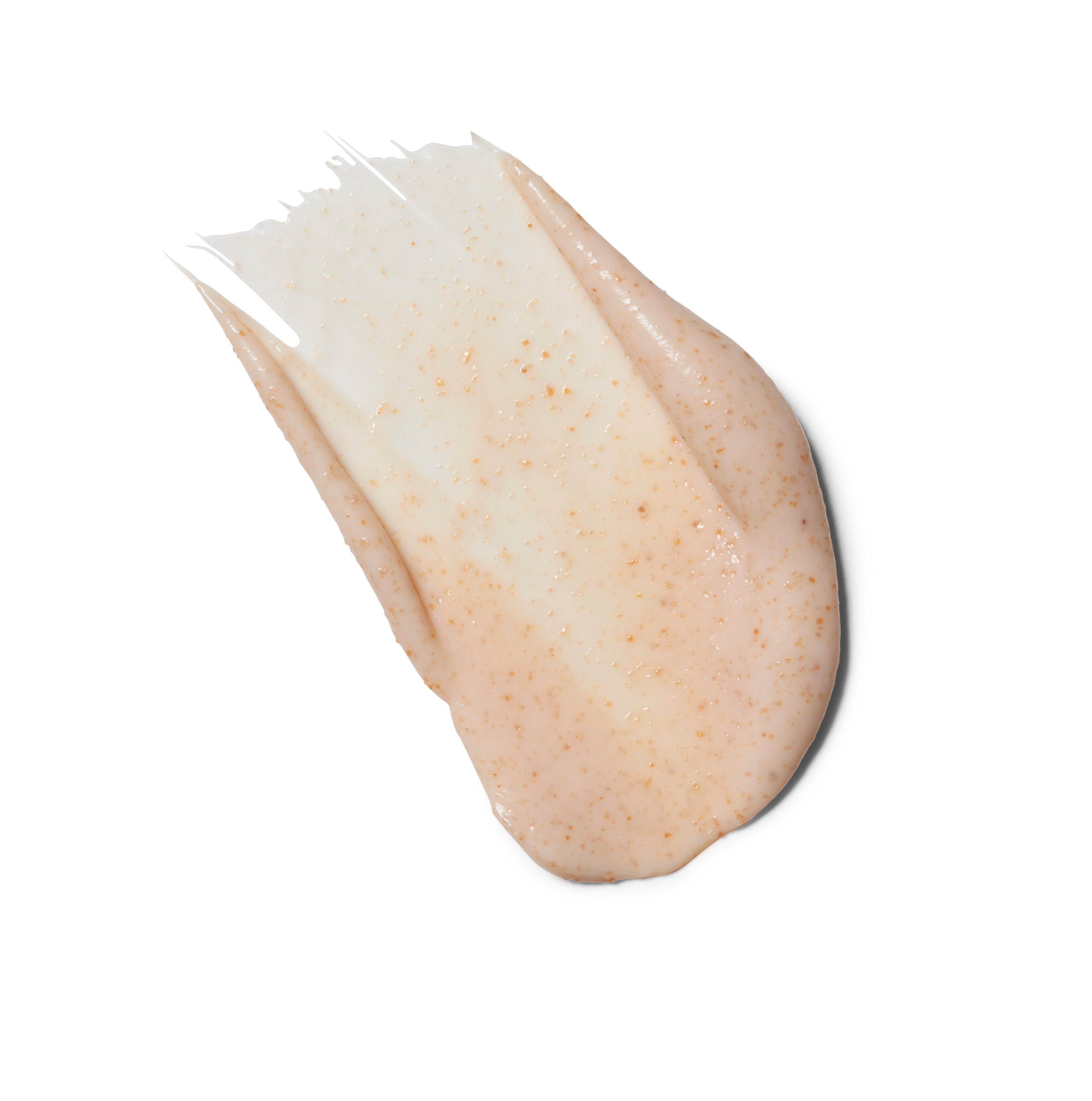 Ausgestrichene rosa Creme mit kleinen Partikeln auf weißem Hintergrund.