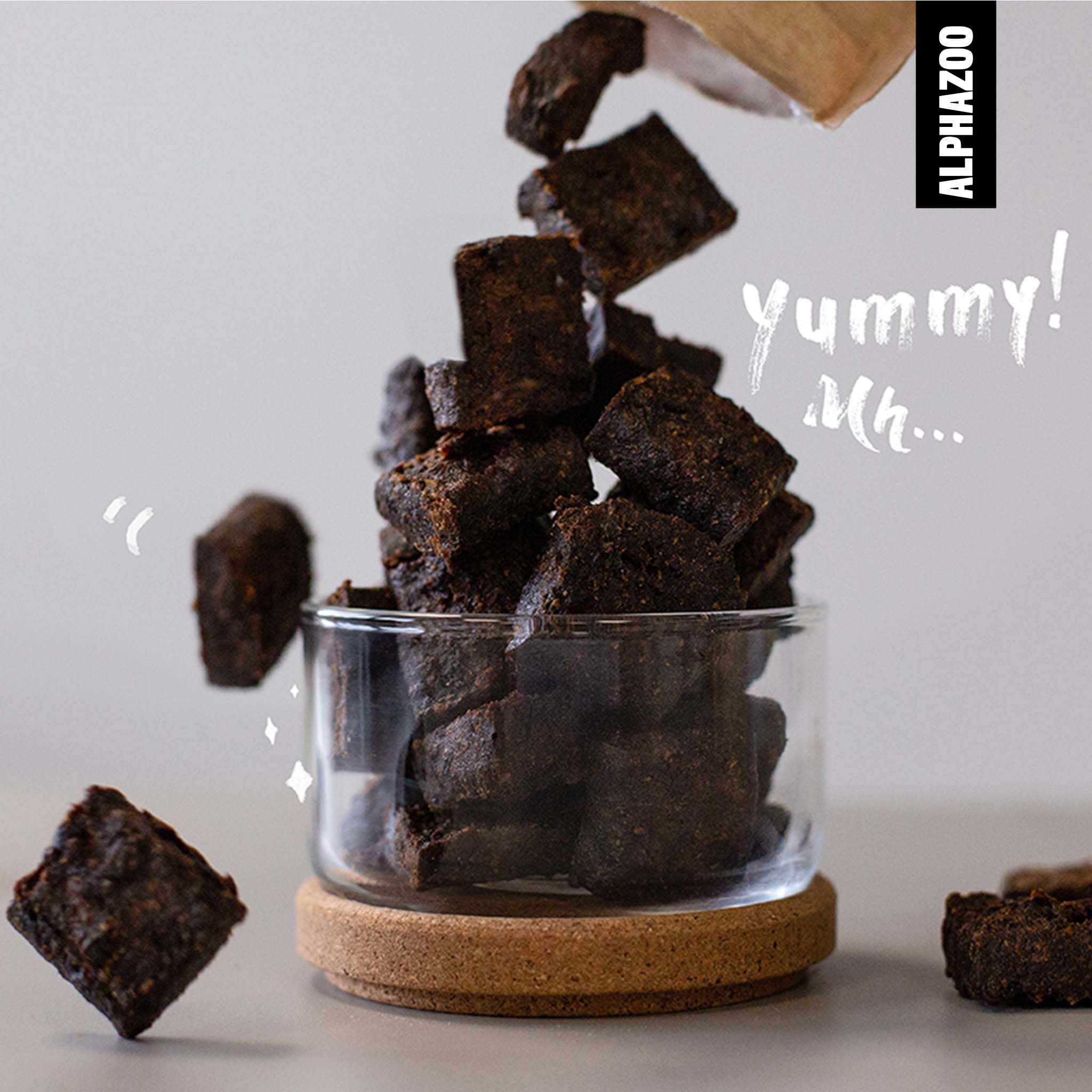 Hundesnacks in Glasbehälter. Snacks fallen in den Behälter. Text: yummy!