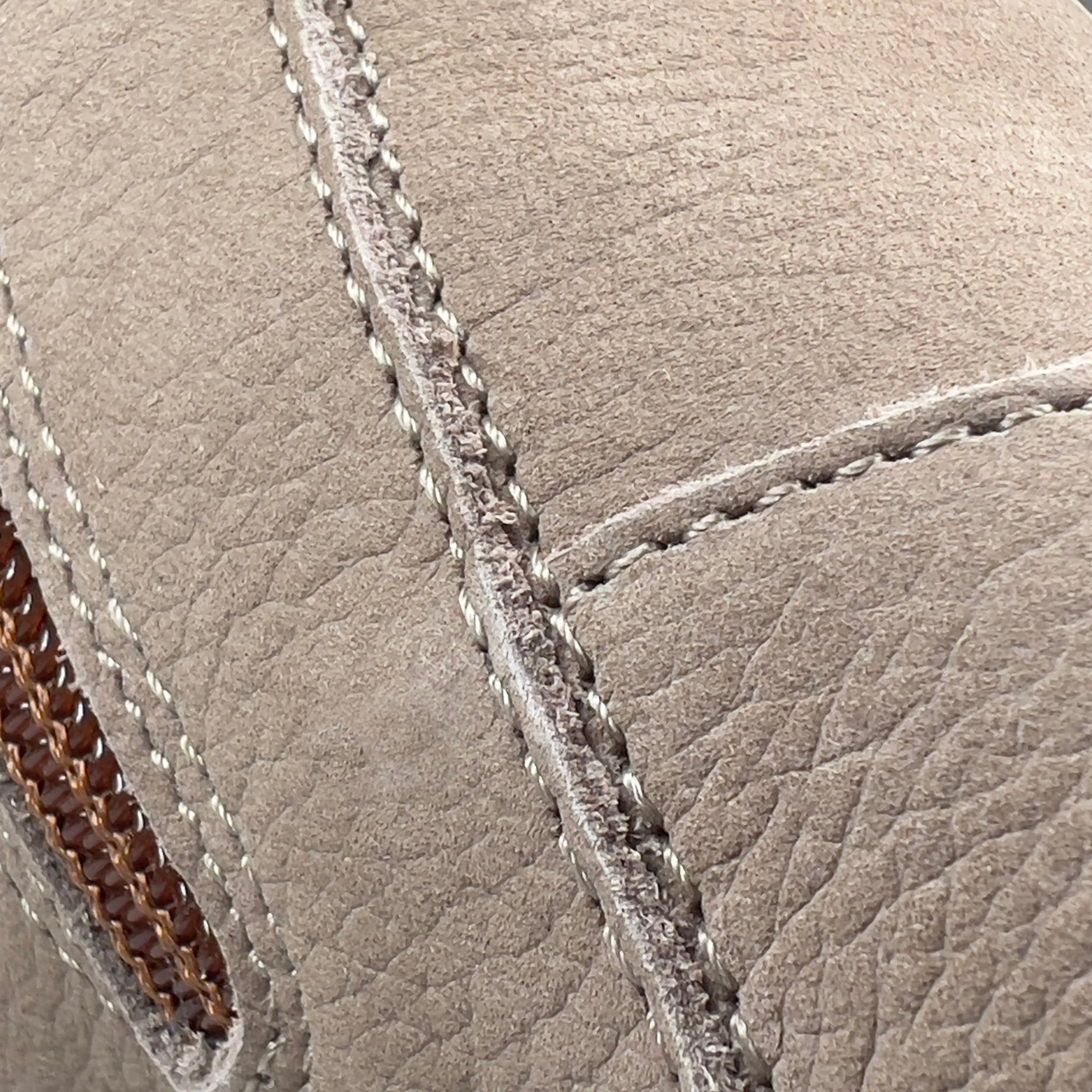 Nahaufnahme der Nahtdetails eines beigen Schuhs. Sichtbare Nähte und Textur des Leders. Detailaufnahme.