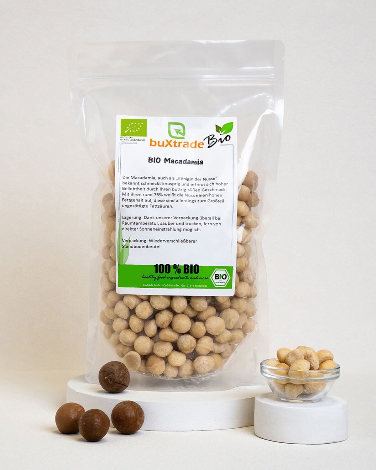 Bio Macadamia Nüsse in transparenter Verpackung, einige Nüsse liegen daneben.