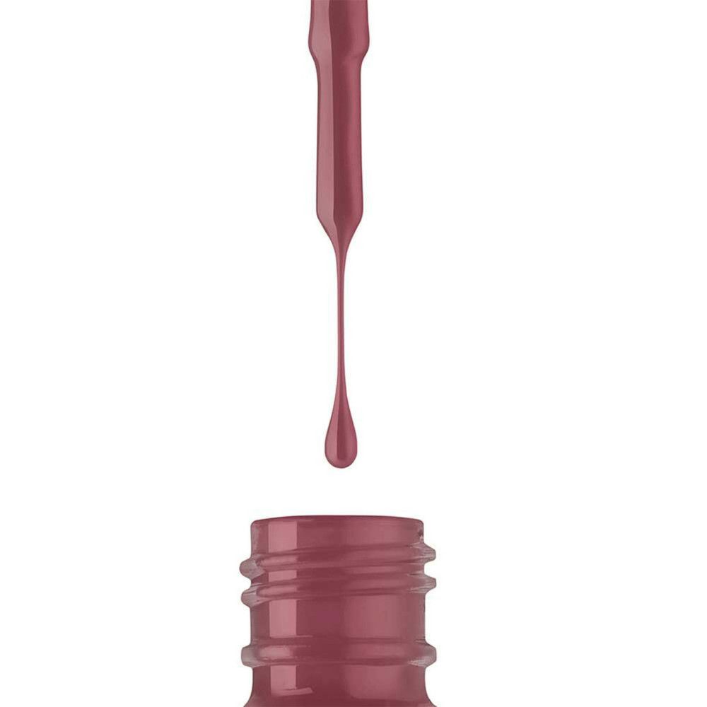 Nagellacktropfen über einer Flasche. Der Pinsel ist sichtbar. Die Farbe ist ein dunkles Rosa.