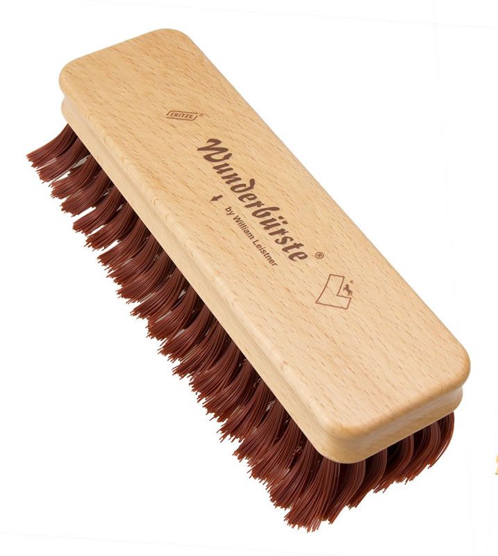 Bürste mit Holzgriff und roten Borsten. Aufschrift: Wunderbürste by William Leistner. Logo.