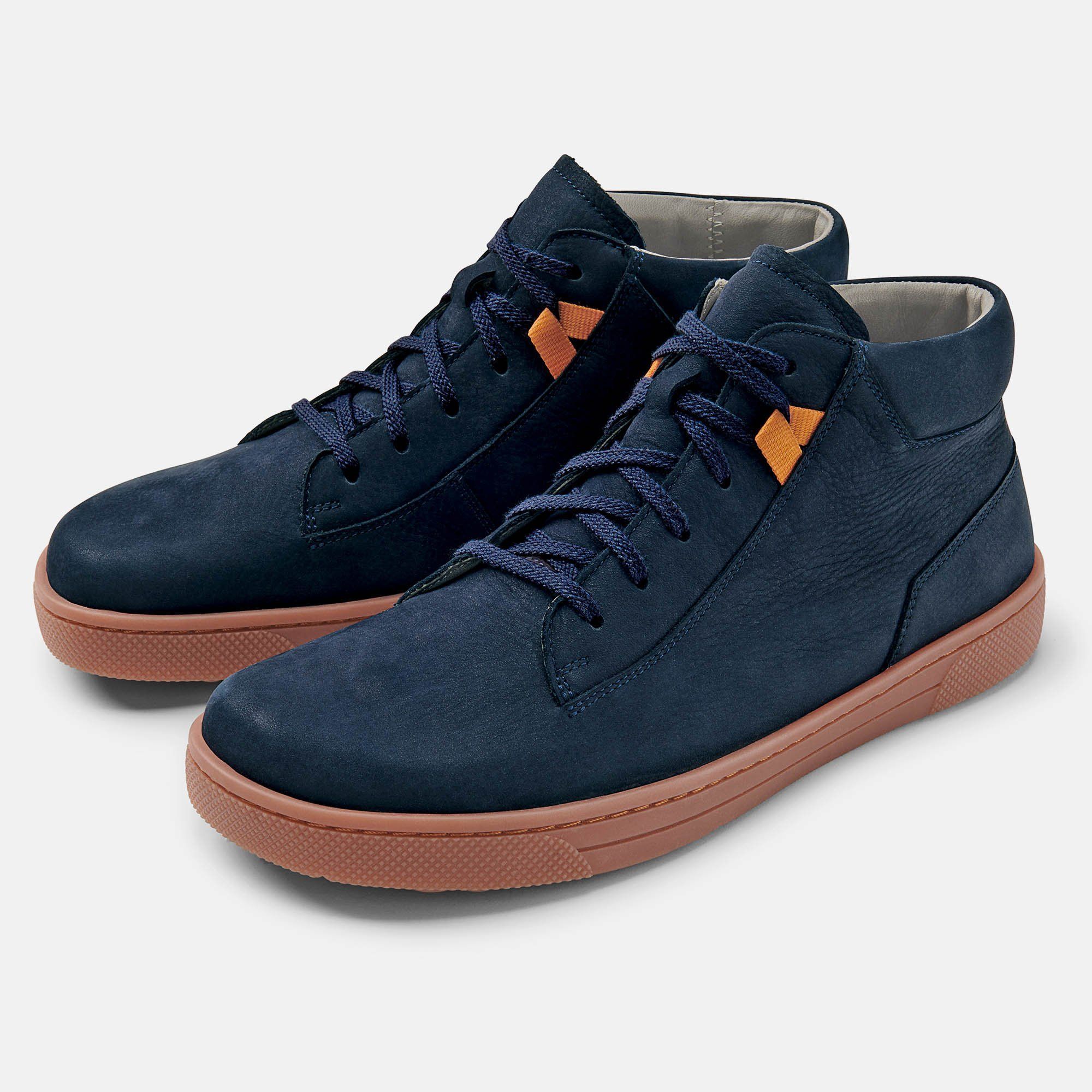 Paar blaue Stiefeletten mit brauner Sohle. Schnürsenkel und orangefarbene Details. Hellgrauer Hintergrund.