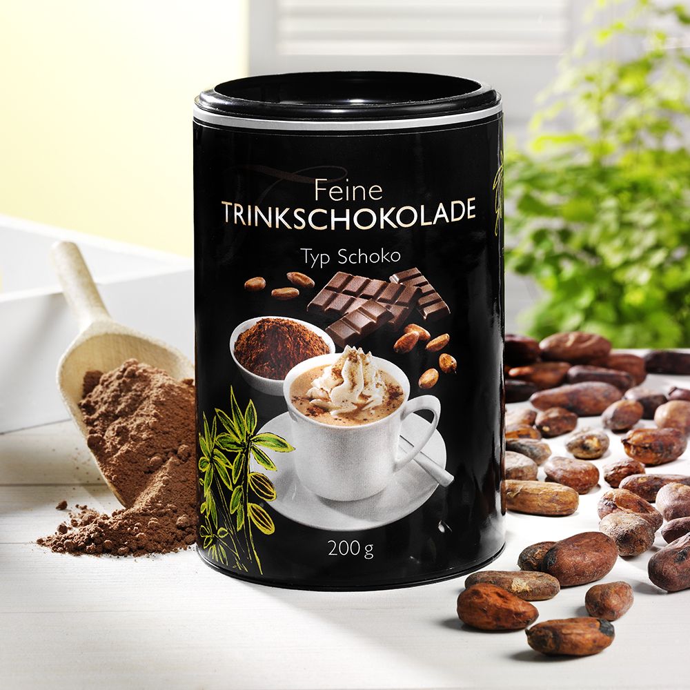 Zylindrische Dose "Feine Trinkschokolade". Abbildung von Schokolade, Kakaopulver, Mandeln und einer Tasse Schokolade mit Sahne. Kakaobohnen.