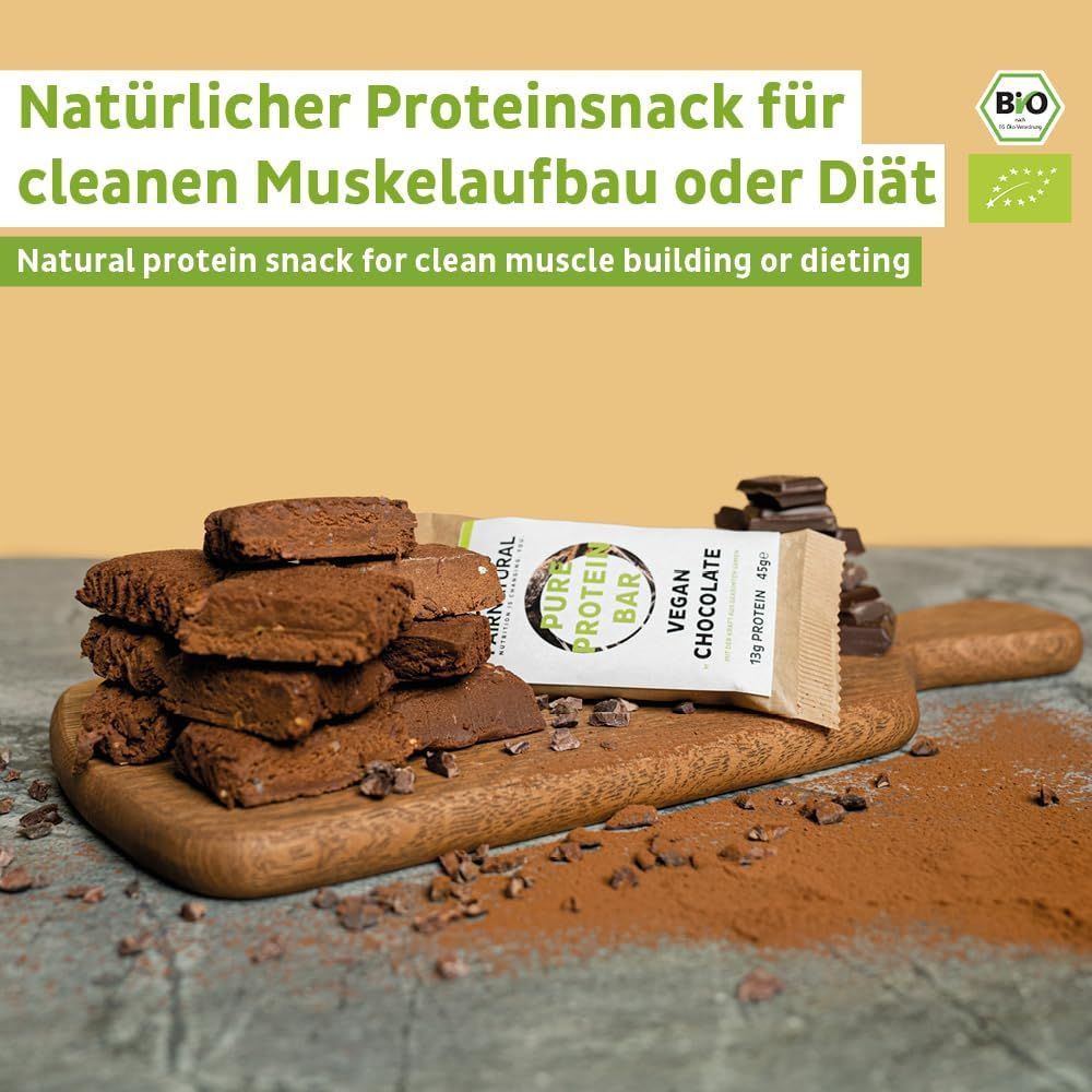 Braune Proteinriegel auf Holzbrett. Daneben ein geöffneter Riegel und Kakaopulver. Bio-Siegel.