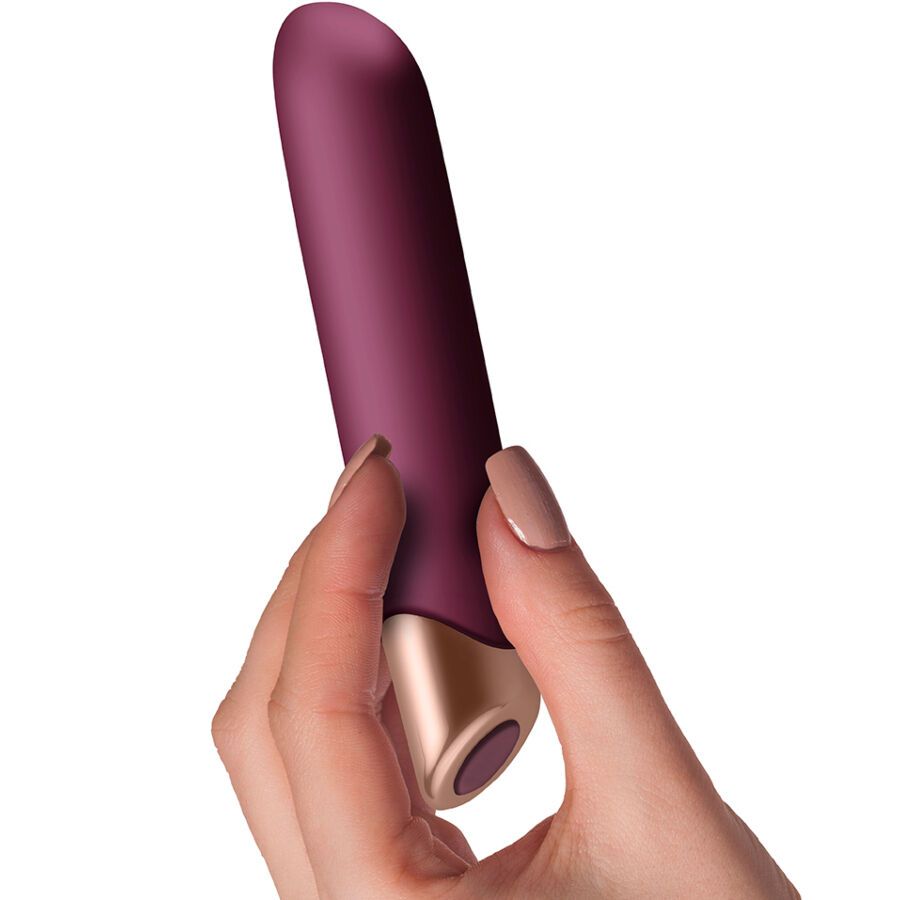 Bordeauxfarbener Vibrator mit goldfarbener Spitze, gehalten von einer Hand. Die Spitze ist abgewinkelt.