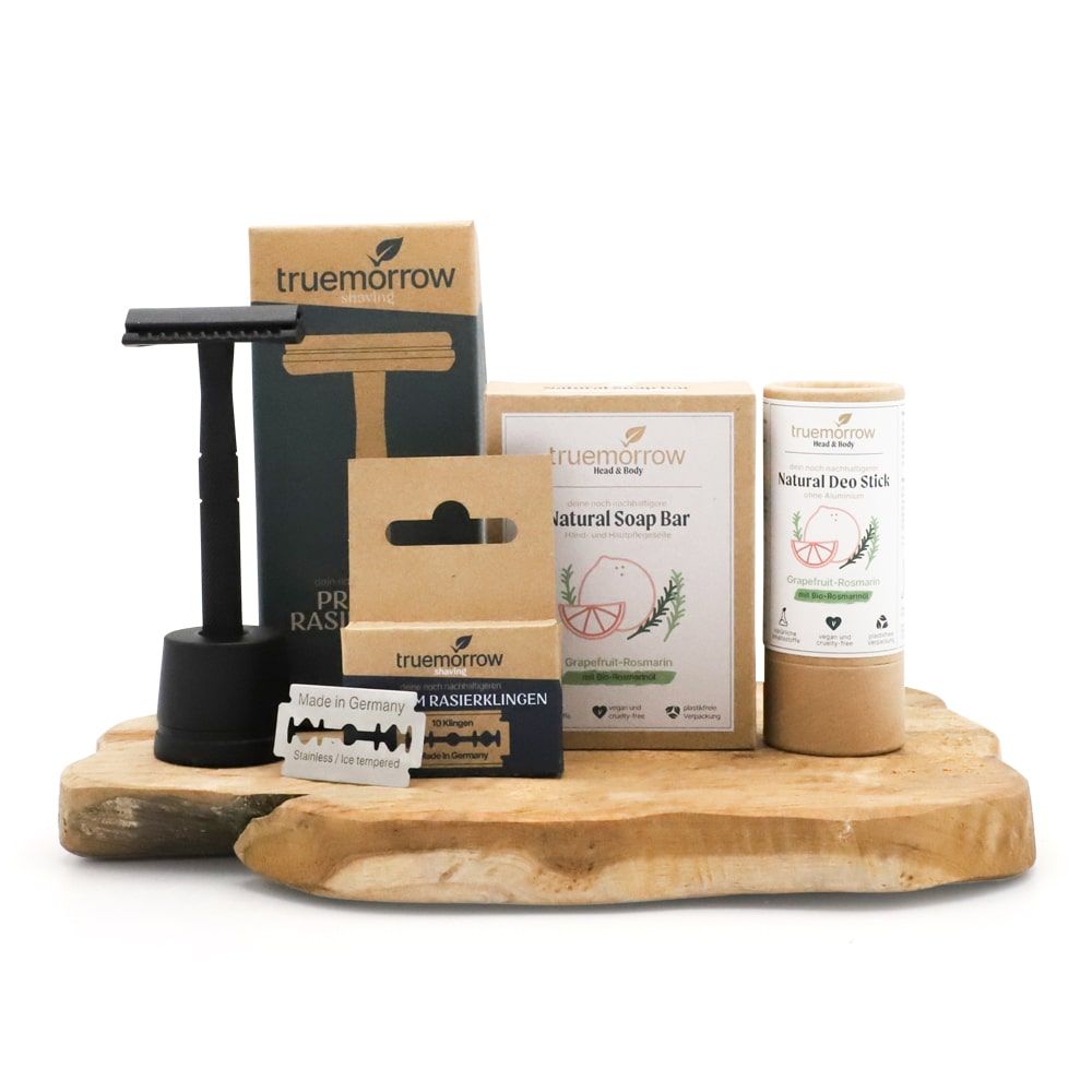 Geschenkset mit Rasierer, Rasierklingen, Seife und Deostift. Schwarzer Rasierer mit Halterung. Verpackungen mit Logo und Produktnamen.