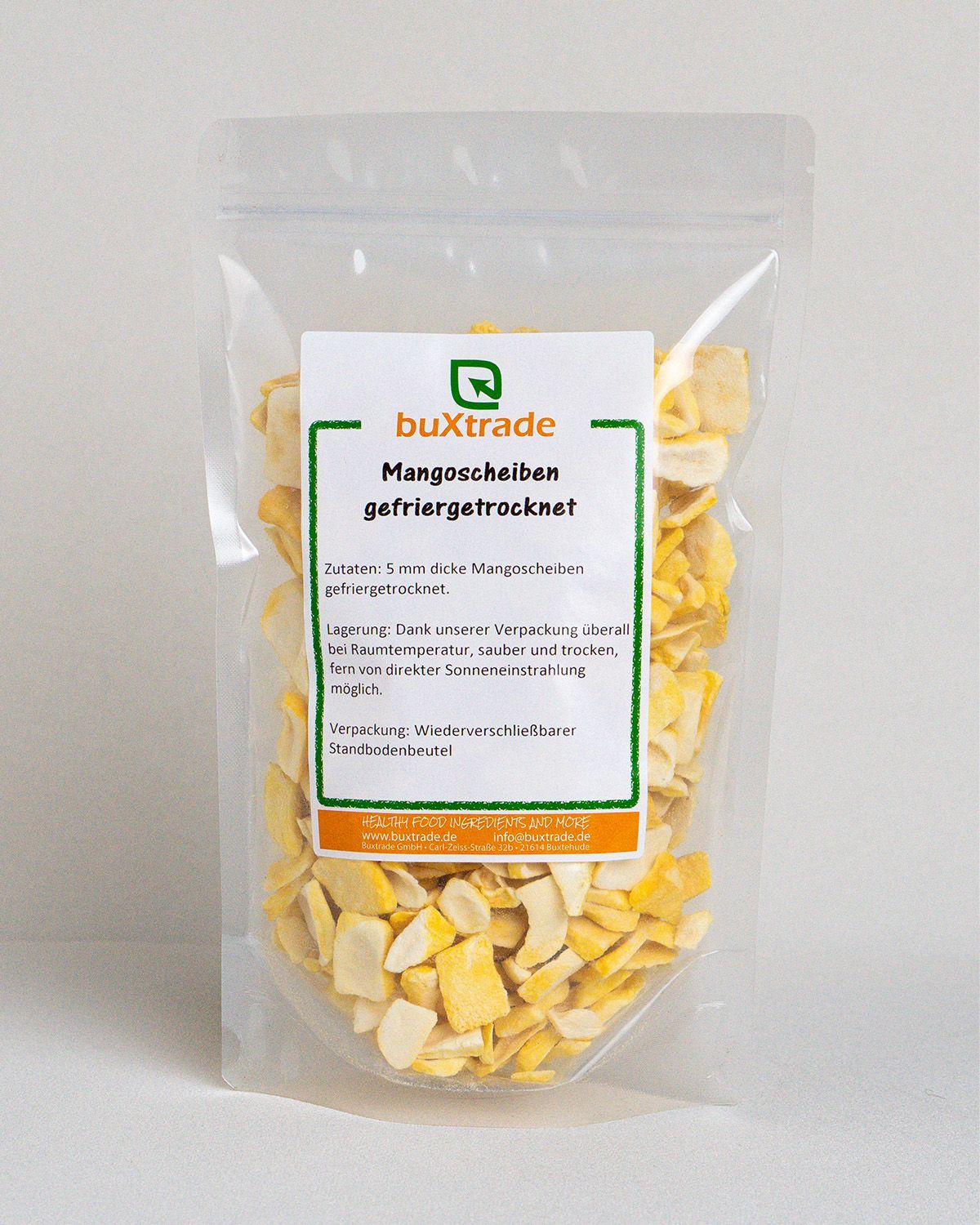 Transparente Verpackung mit buXtrade Mangoscheiben gefriergetrocknet. Aufkleber mit Produktinformationen.