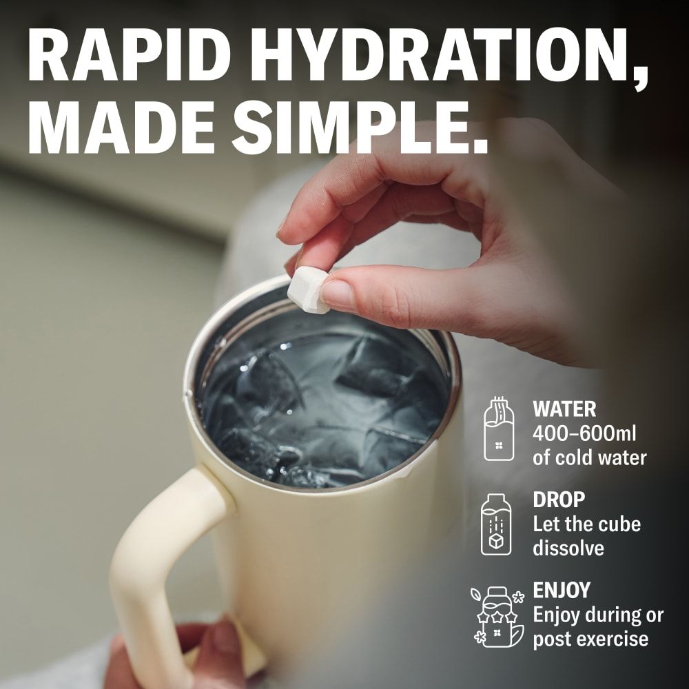 Hand gibt einen waterdrop® Hydration Cube in ein Glas mit Eiswasser, um ein Getränk zuzubereiten.