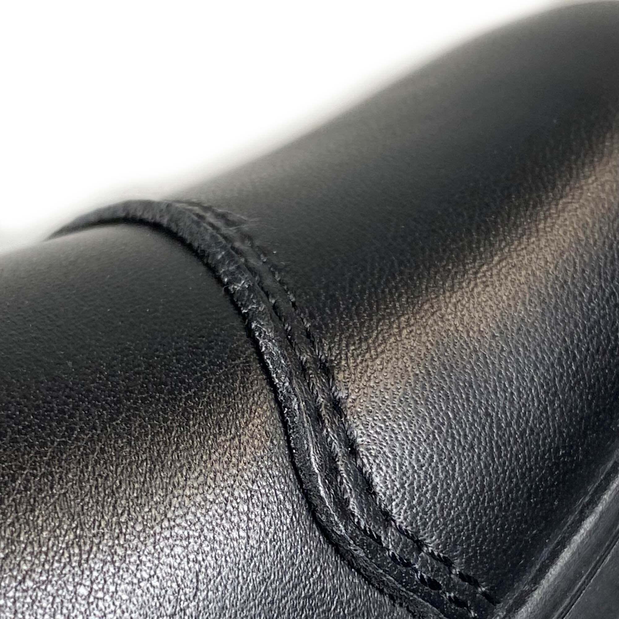 Detailansicht des seitlichen Reißverschlusses einer schwarzen Leder-Stiefelette.