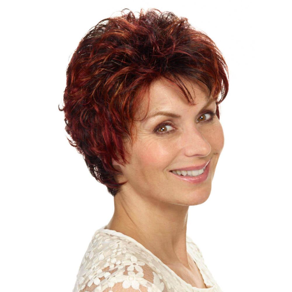 Kurzhaarperücke, rotbraun, gewellt. Frau mit Perücke, Blick zur Kamera, weißes Oberteil.