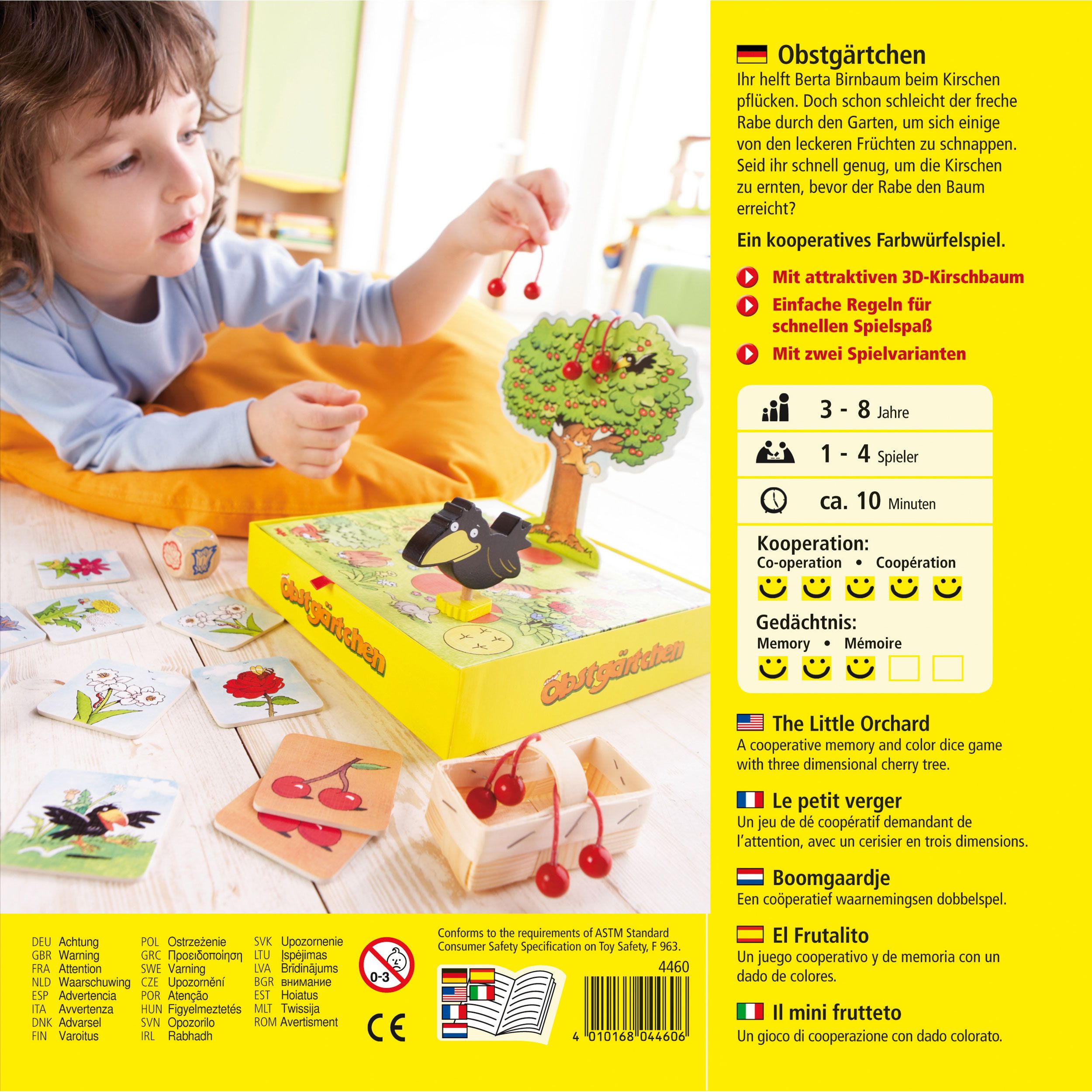 Kind spielt mit Spiel. Spielbrett mit Baum, Korb mit Kirschen, Rabe und Spielkarten. Text in Deutsch und Englisch. Altersempfehlung.