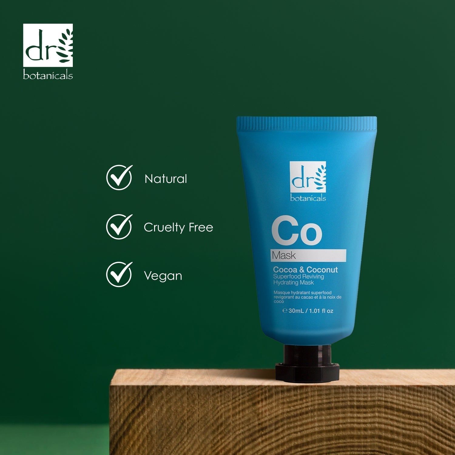 Blaue Tube auf Holzblock. Aufschrift: Co Mask, Cocoa & Coconut Superfood Reviving Hydrating Mask. Marke: dr botanicals. Logos: Natural, Cruelty Free, Vegan.