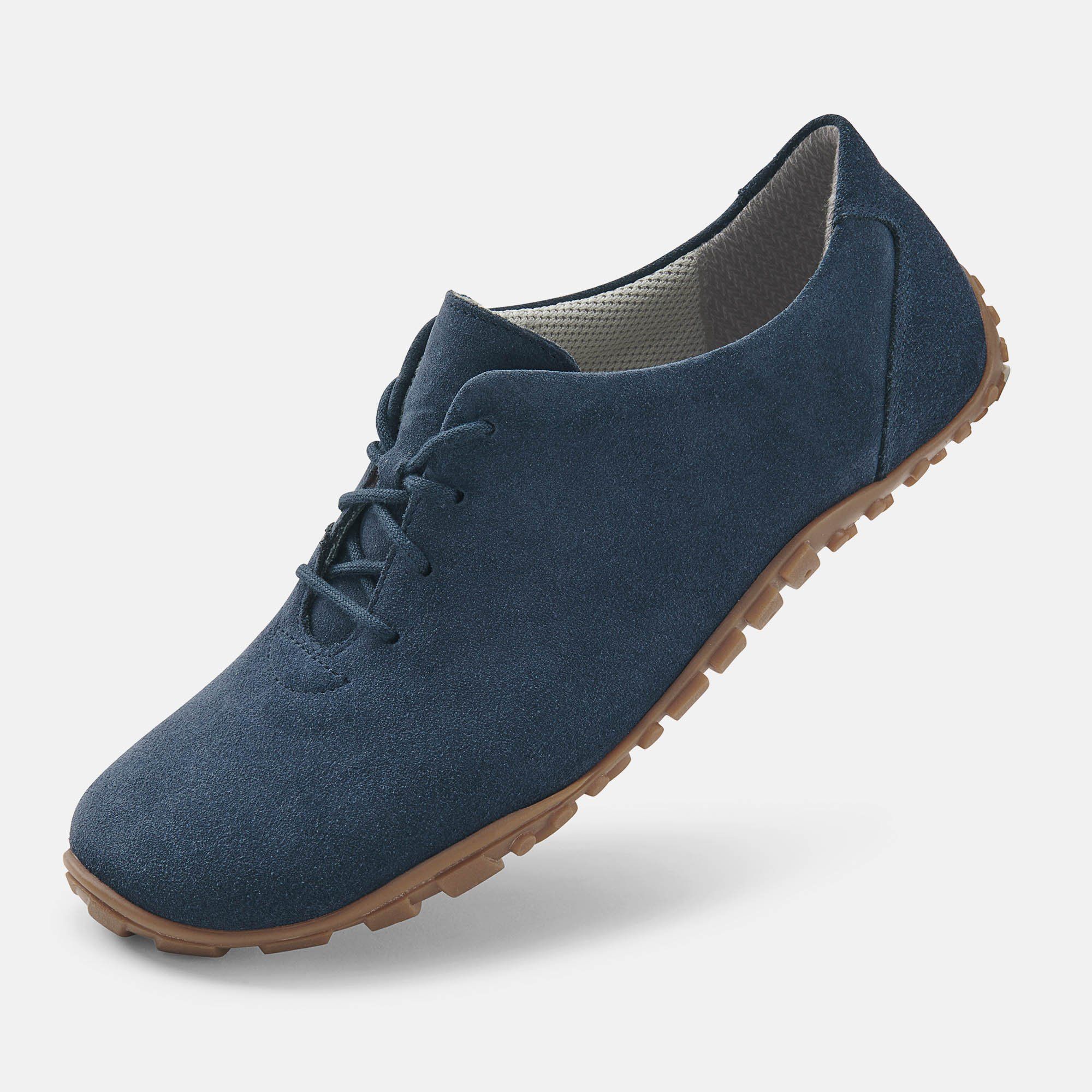 Blauer Schnürschuh mit brauner Sohle. Obermaterial aus Wildleder. Flache Sohle mit Profil. Hellgraues Innenfutter. Schuh leicht schräg.