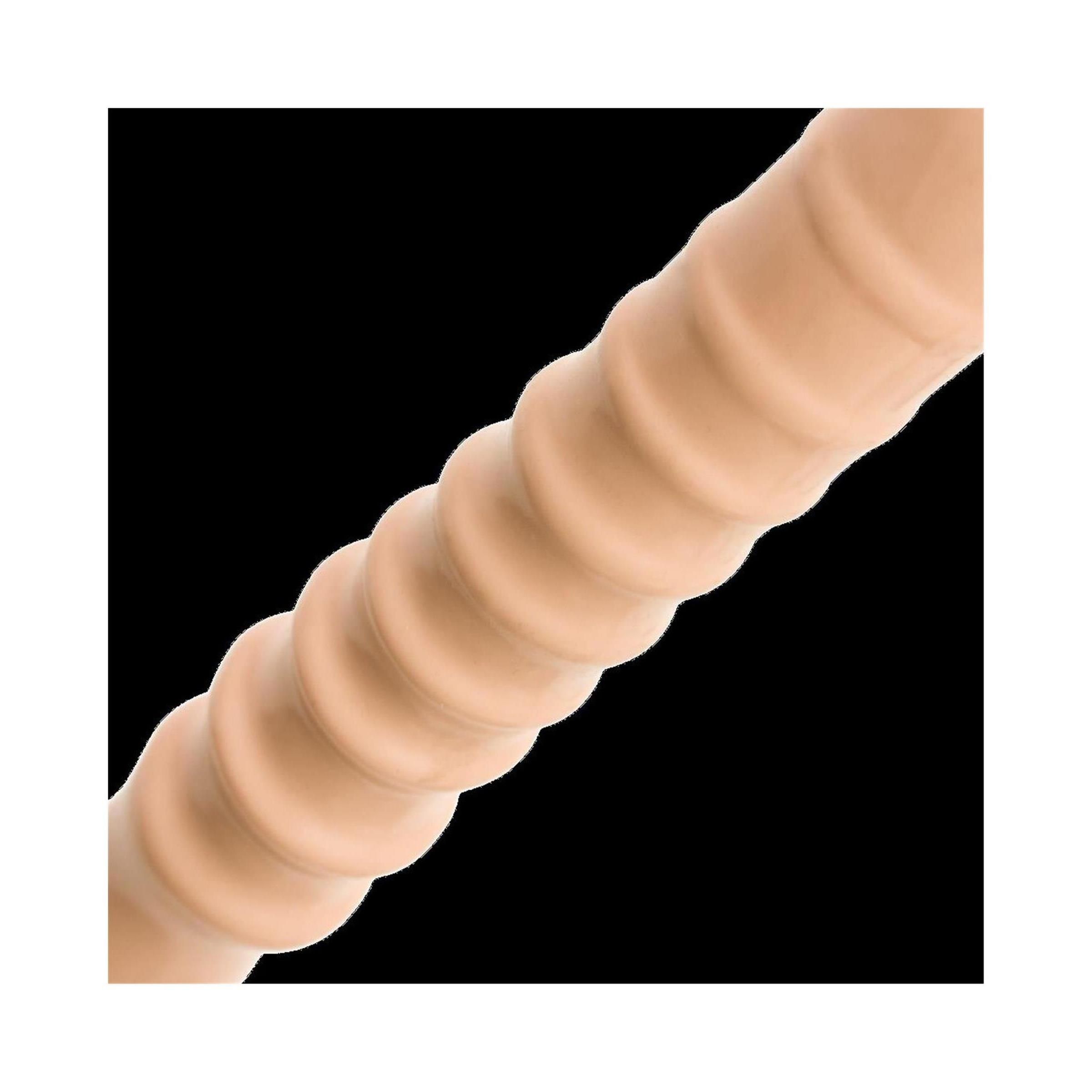 Nahaufnahme eines beigen Dildos. Geriffelte Oberfläche, wellenförmiges Design. Gezeigt auf schwarzem Hintergrund.