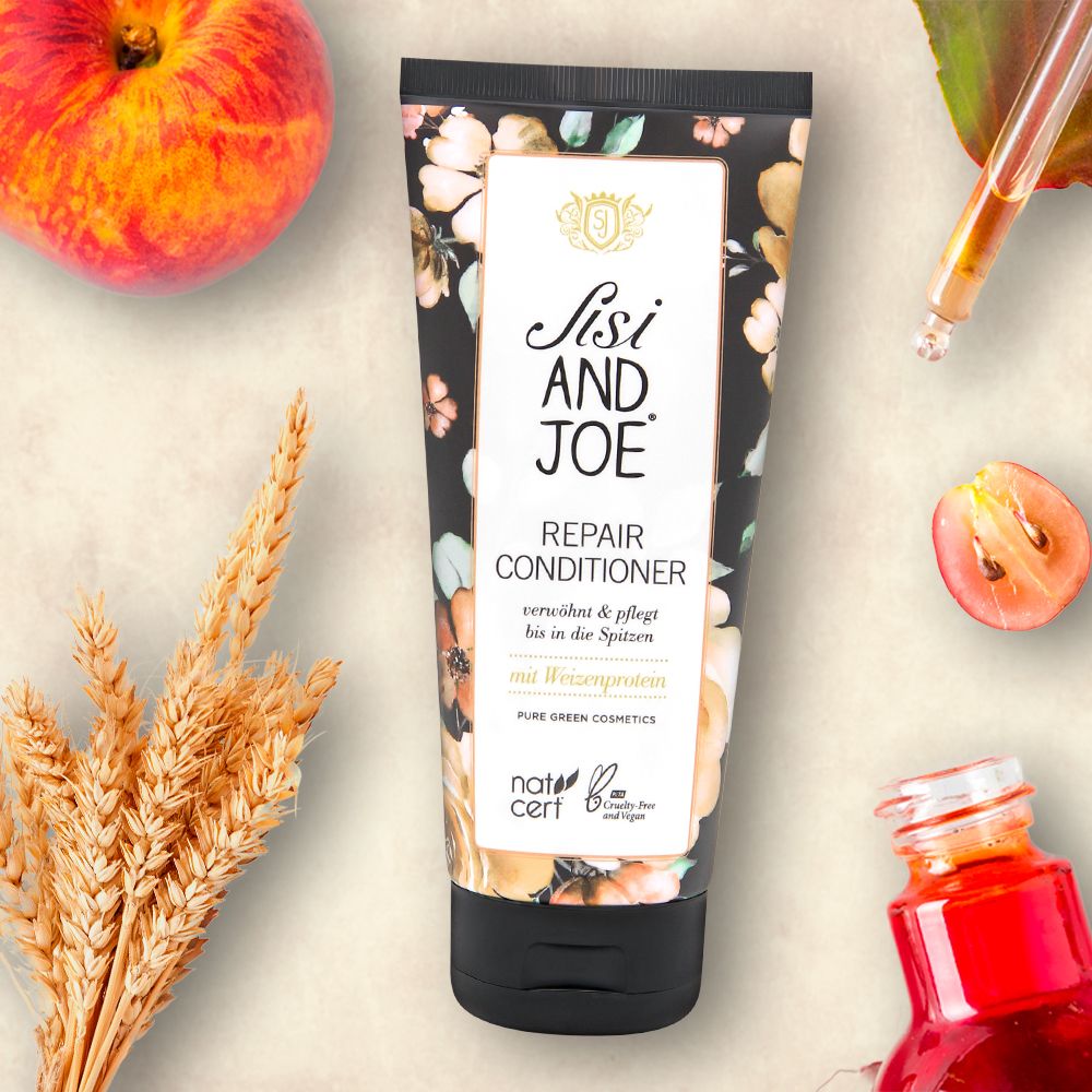 Tube mit floralem Muster und Produktinformationen. Aufschrift: Sisi and Joe Repair Conditioner mit Weizenprotein. Natrue-Zertifizierung.