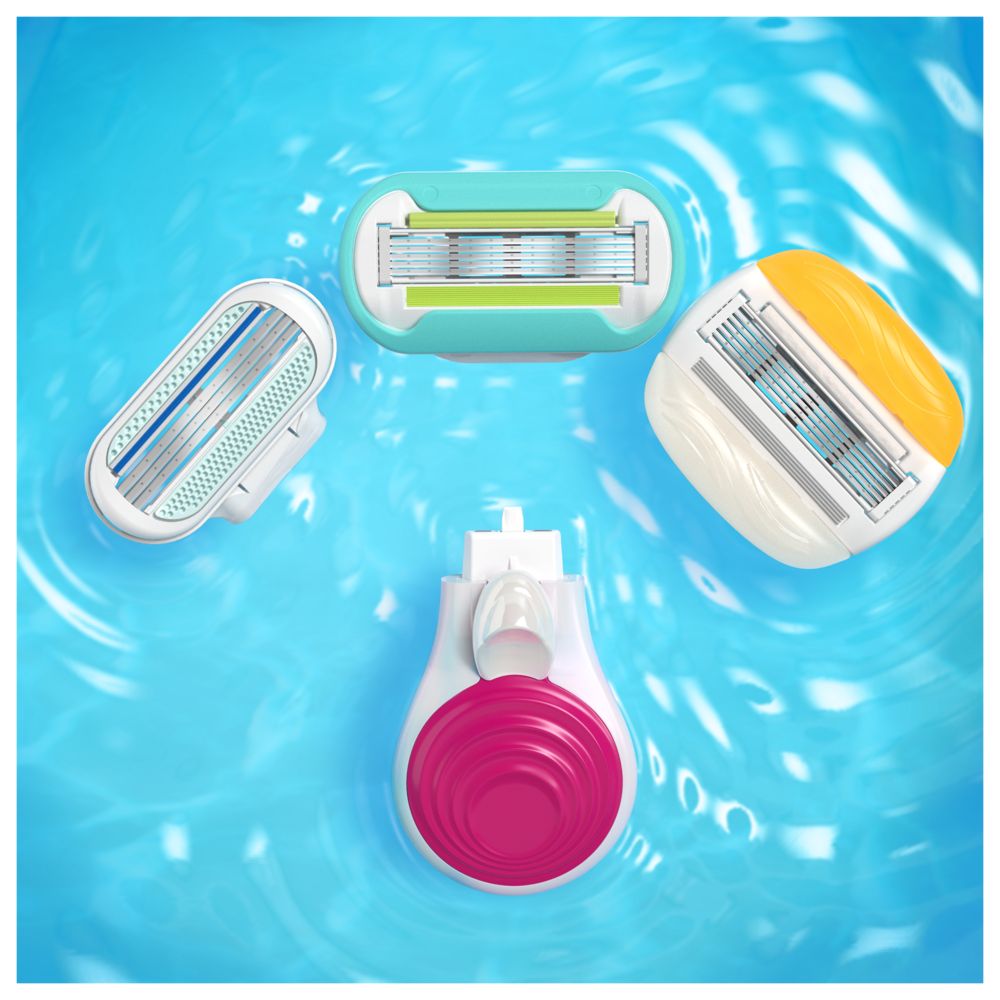 Drei Rasierköpfe und ein Rasierergriff im Wasser. Verschiedene Farben: blau, gelb, grün. Nahaufnahme.