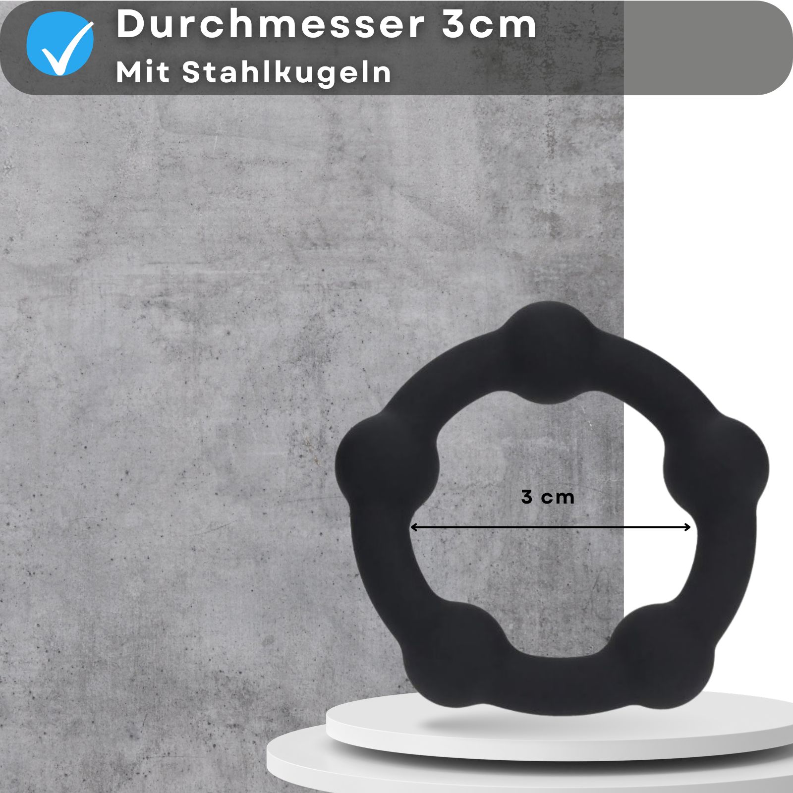 Ein schwarzer Penisring mit Stahlkugeln. Durchmesser 3cm. Aufschrift: Durchmesser 3cm, mit Stahlkugeln.