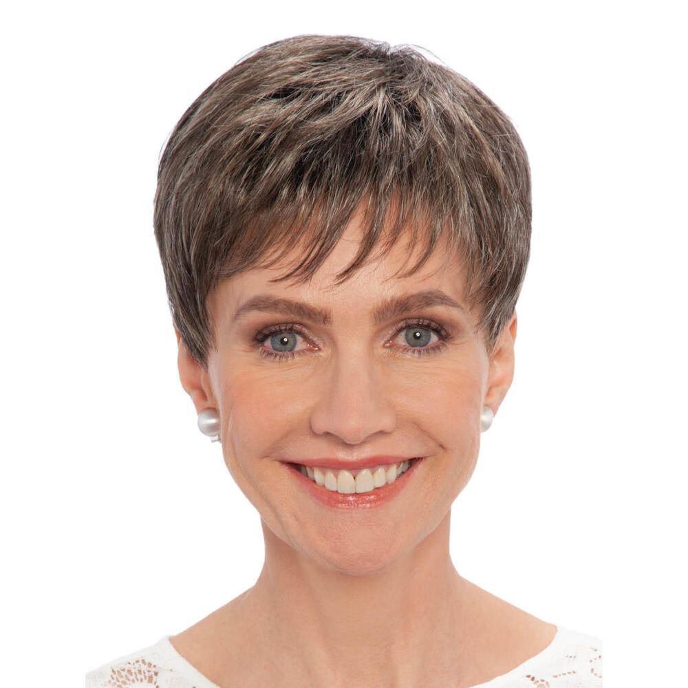 Kurzhaarperücke mit grauen Strähnen. Die Frau trägt Perlenohrringe und ein weißes Oberteil. Frontansicht.