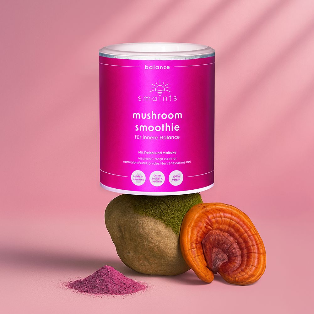 Dose mit Produkt, platziert auf einem Stein und Pilz. Rosa Dose mit Text. Aufschrift: smaints mushroom smoothie.