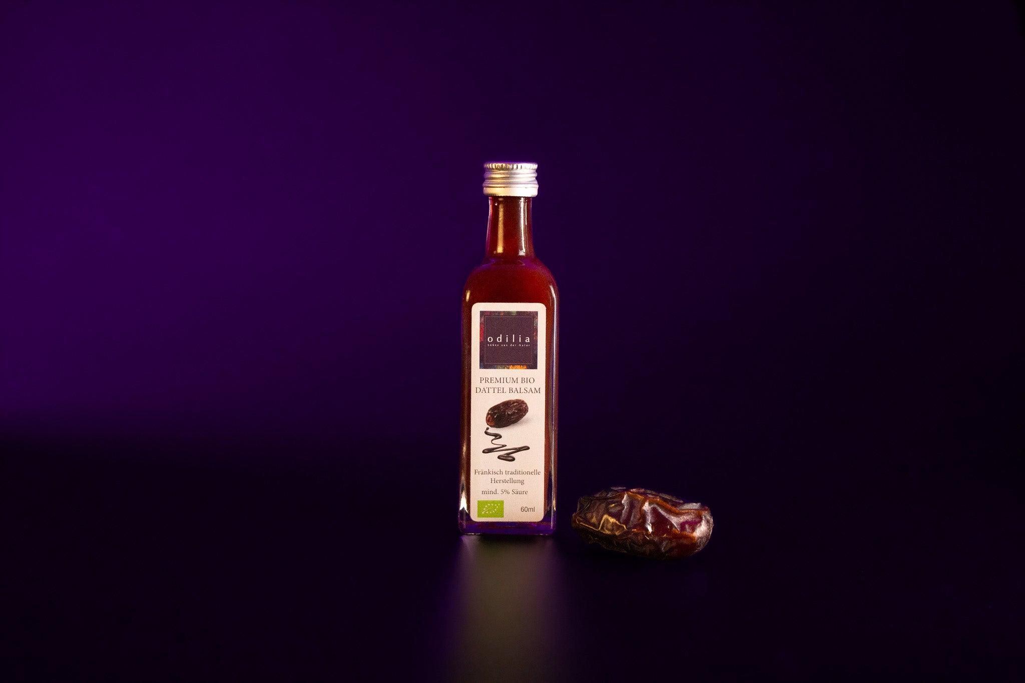 Flasche mit Bio-Dattelsirup von Odilia auf dunklem Hintergrund.