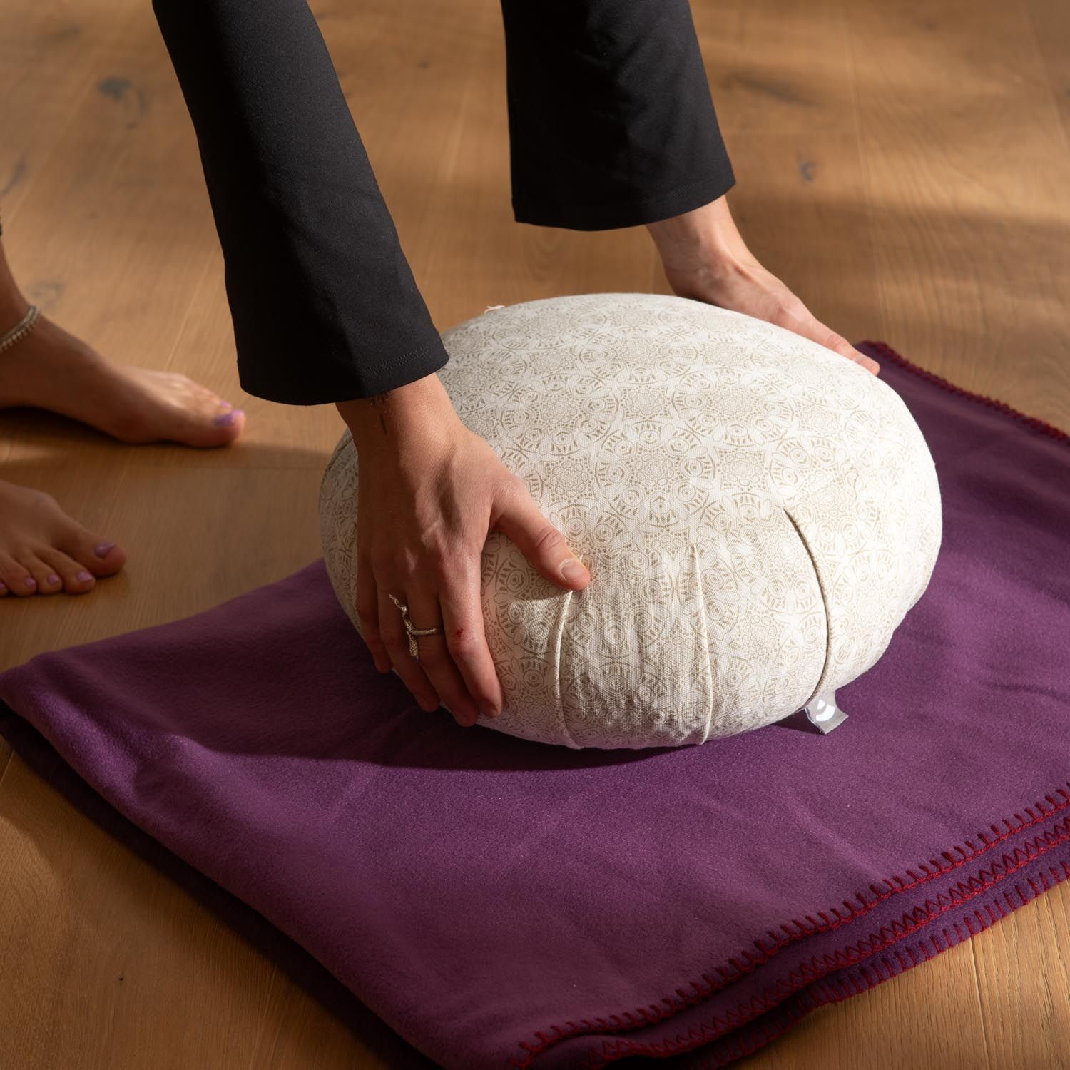 Bodhi Zafu Meditationskissen mit Muster auf lila Unterlage.