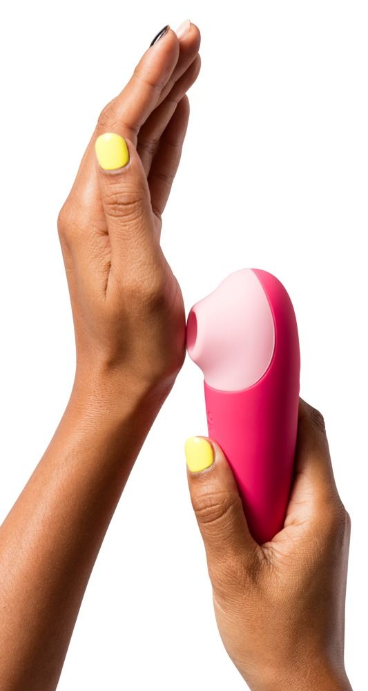 Hände halten einen rosa Vibrator. Der Kopf ist rosa. Gelbe Nagellackfarbe.