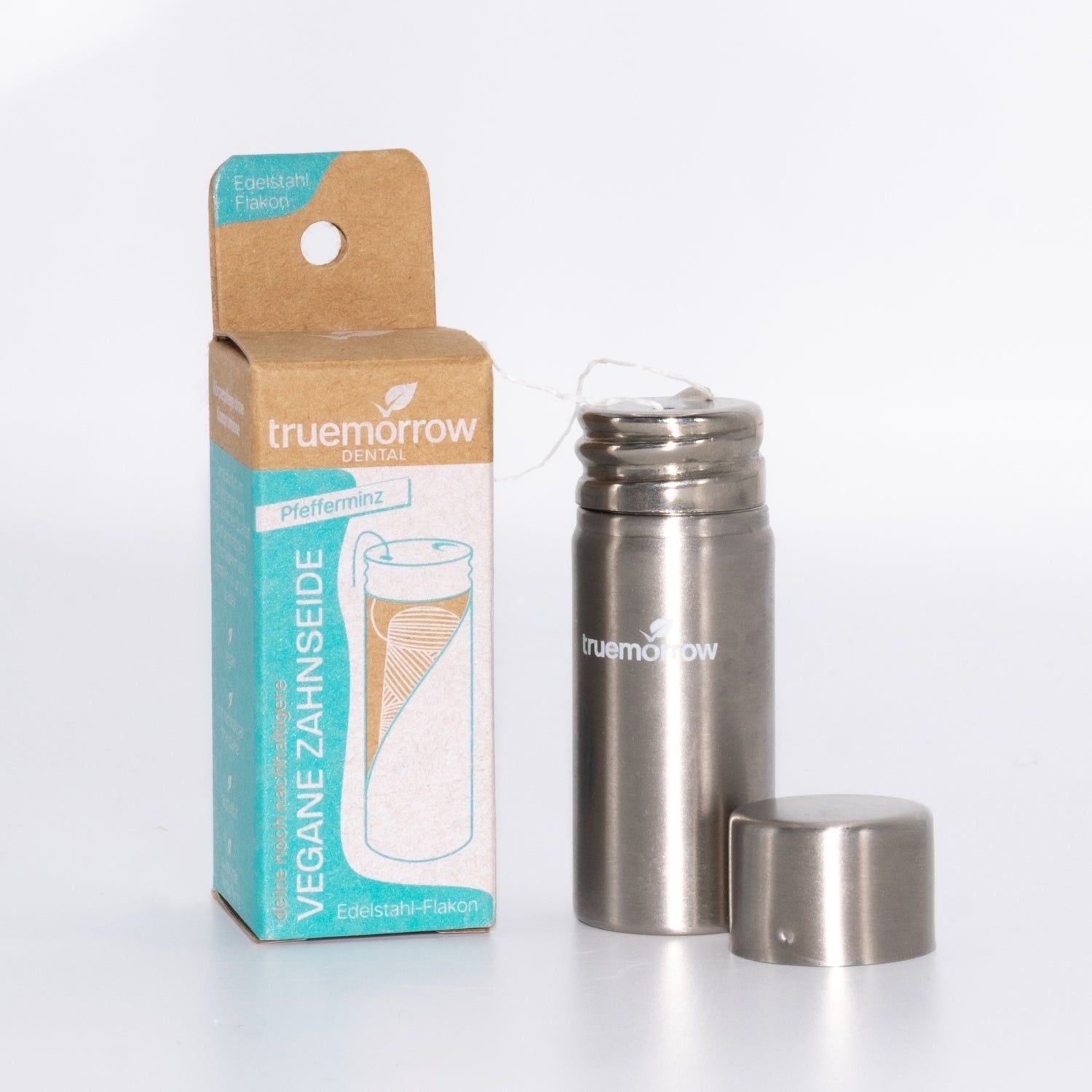 Zahnseide-Flakon aus Edelstahl, mit Kartonverpackung. Aufschrift: truemorrow dental, Vegane Zahnseide, Pfefferminz.